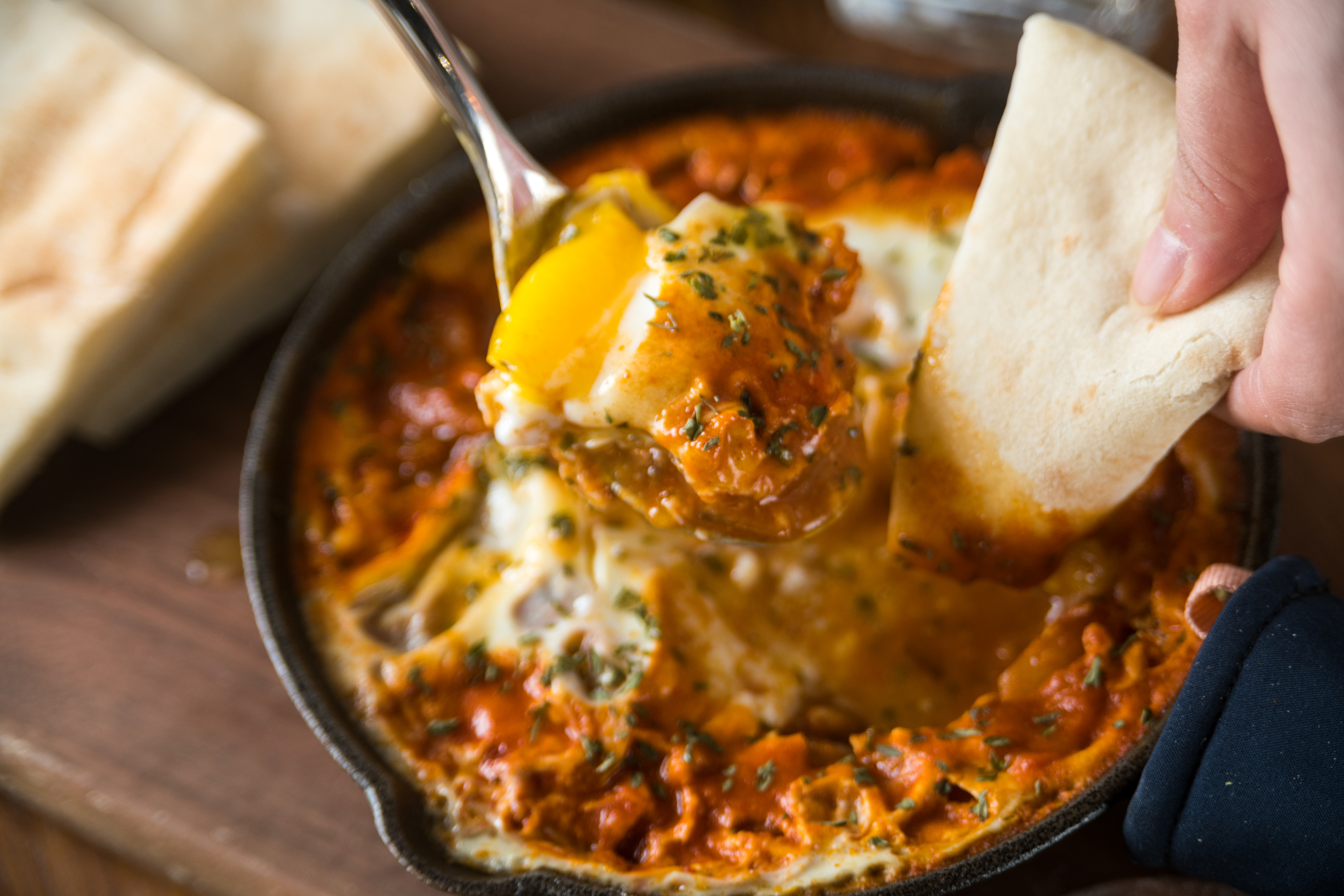 以色列國民早餐「夏卡蘇卡」，敲破水波蛋，黃金蛋液與香料番茄醬一起吃，酸爽開胃，必點。（320元／份）