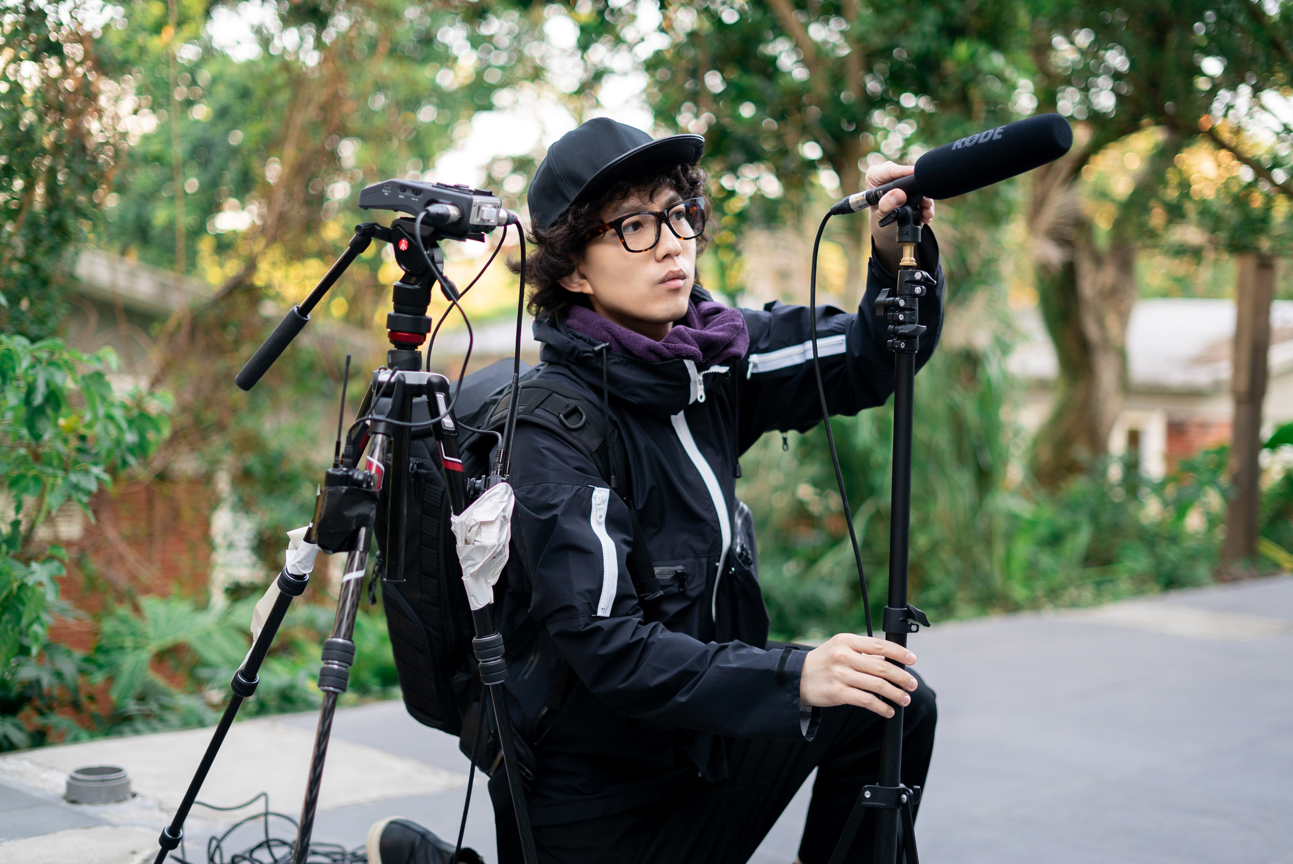 林宥嘉應社群論壇 Dcard之邀，戴上大捲髮、帽子與眼鏡，變身一日實習攝影助理。（華研國際提供）