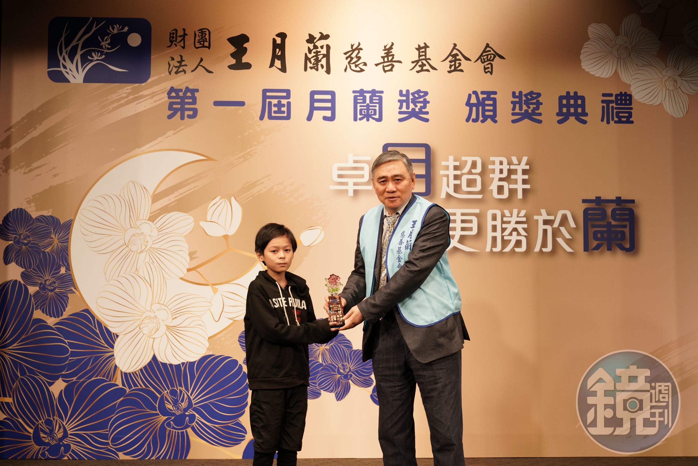 財團法人王月蘭慈善基金會董事長王文洋先生於第一屆月蘭獎頒獎典禮，頒發月蘭獎給得獎學童-許中瑋小朋友。