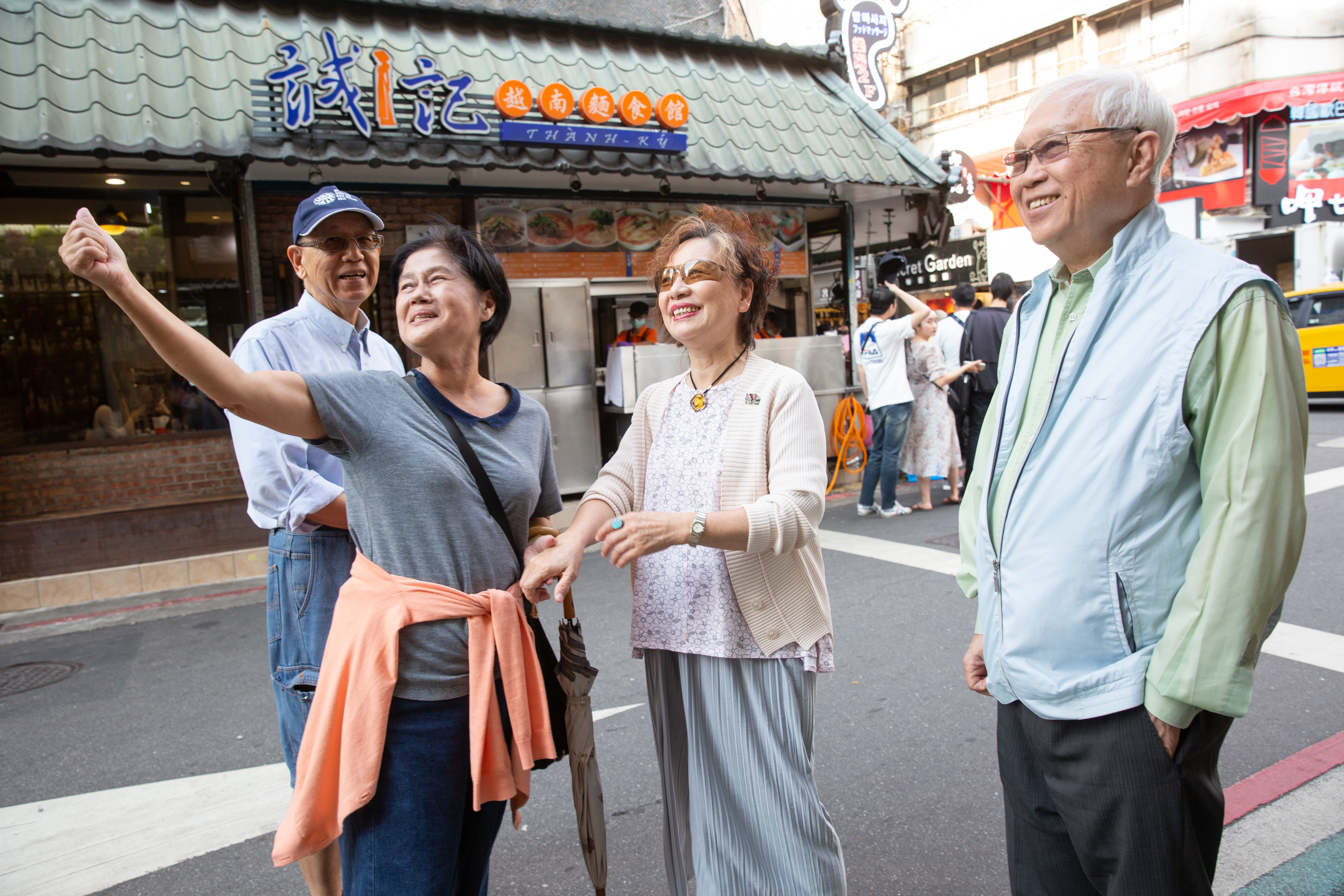 80年代，杜漢琛（右）與妻子鄭曼蕙（右2）在永康街擺攤賣起越南河粉。採訪這天，不少老鄰居前來和他們打招呼。