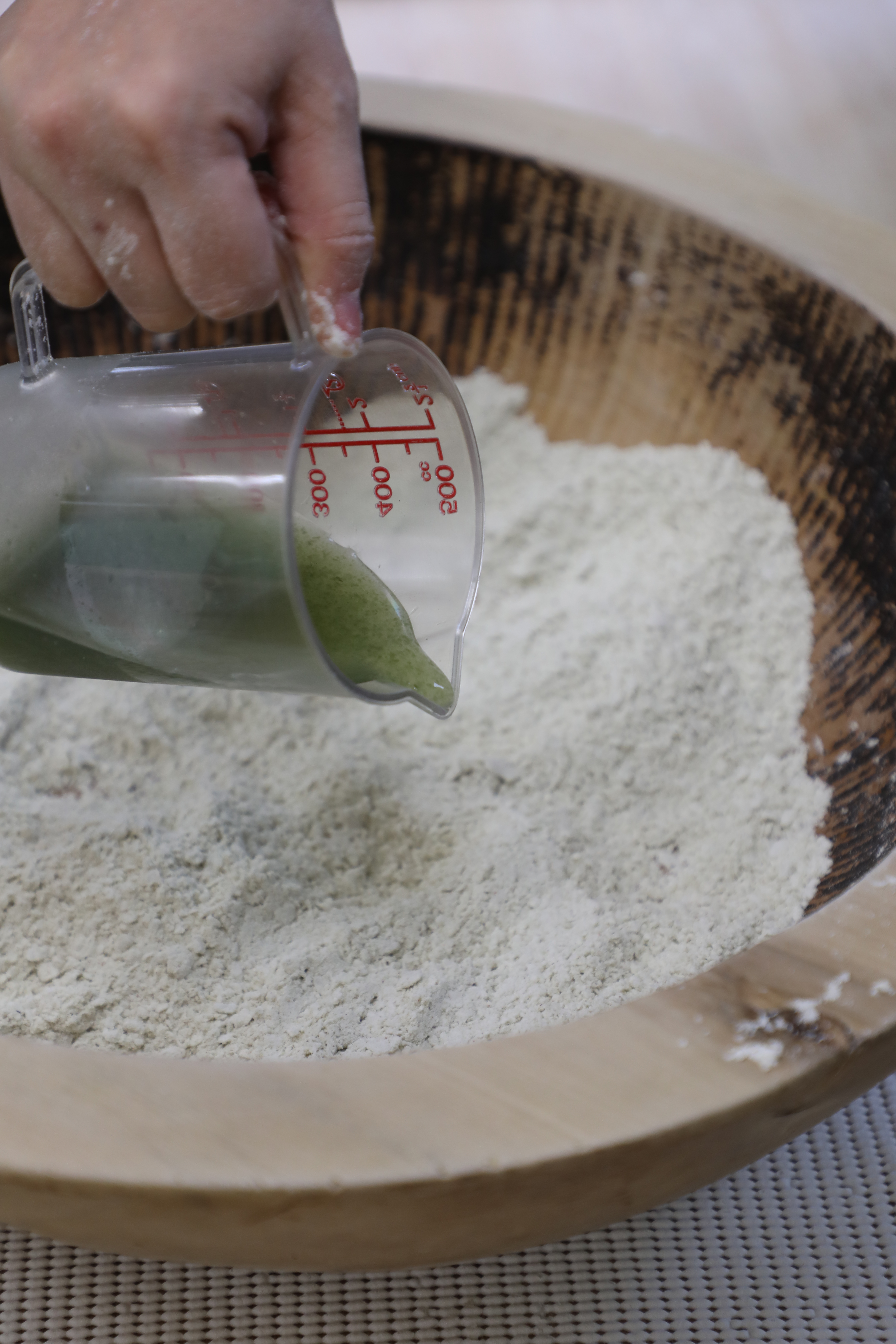 在蕎麥粉中分3次倒入布海苔汁液，並充分混合。