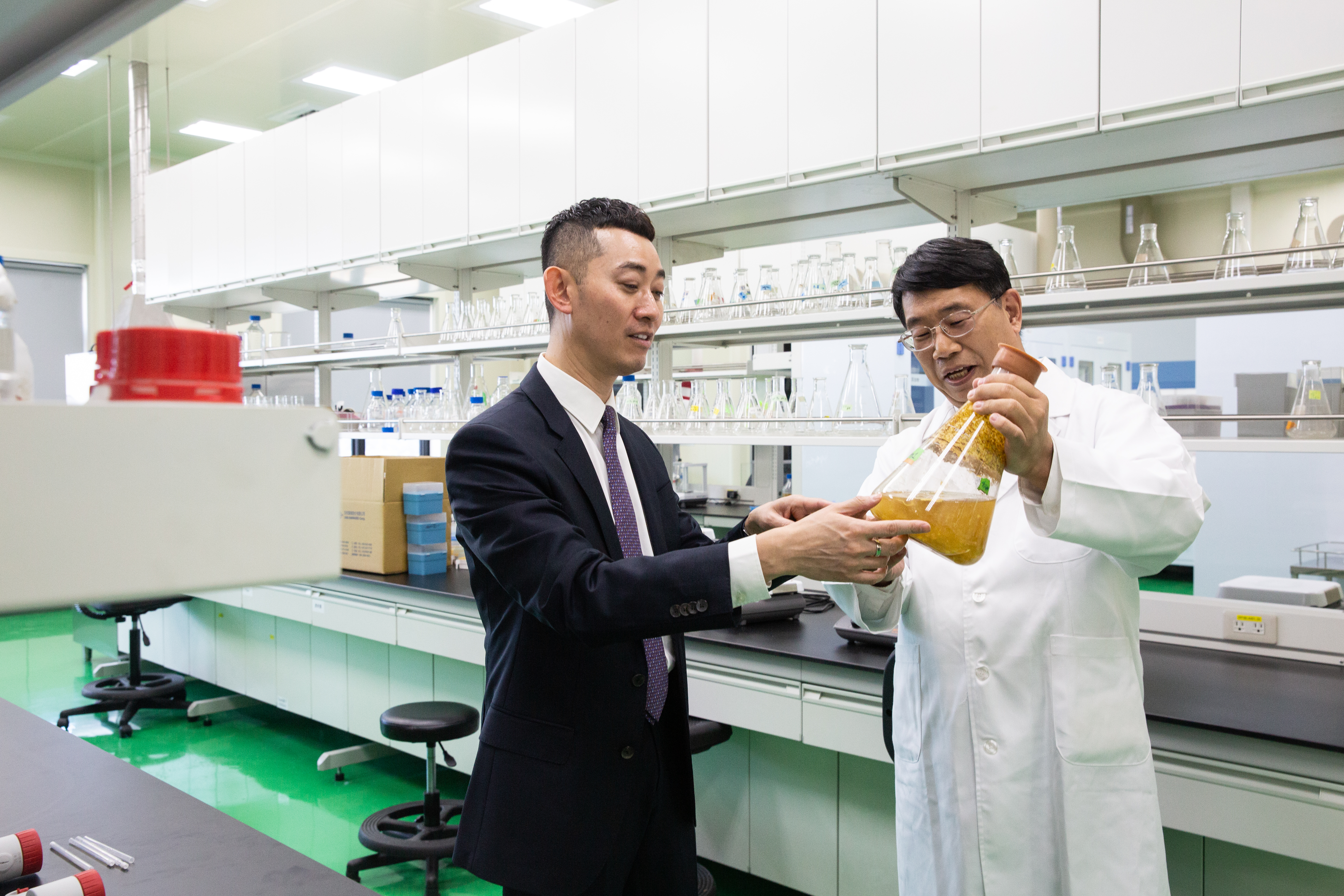 當初父親挖角陳勁初（右），首創以生物反應槽培養靈芝，至今曾盛麟仍相當倚重他。