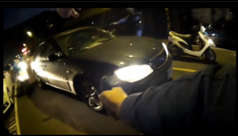 李、孟2嫌闖紅燈遭警攔查卻拒不停下車，警持槍喝令下車。（翻攝畫面）