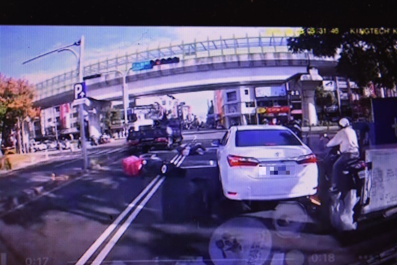 黎男在地方翻滾,幸好貨車有防捲裝置,沒被捲入車下。(翻攝畫面)