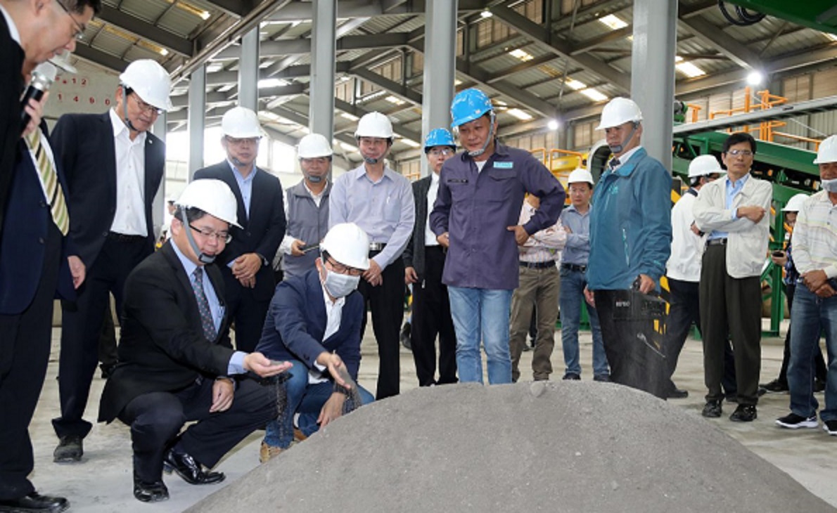 李孟諺（蹲者左）代理市長任內出席焚化底渣廠開幕儀式，該廠惹爭議，他特別提出說明，強調評選過程一切依法。（翻攝自環保局官網）