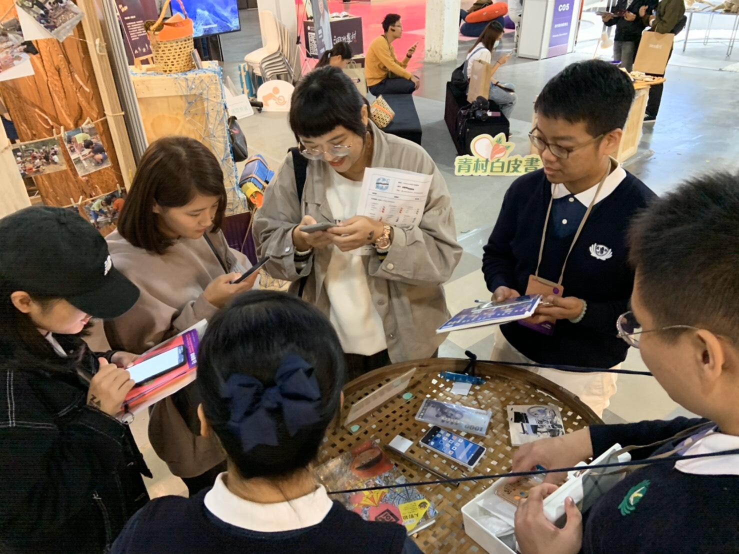 在慈濟基金會的攤位上，總圍繞許多年輕人來體驗「青年來抓周」活動。（翻攝畫面）