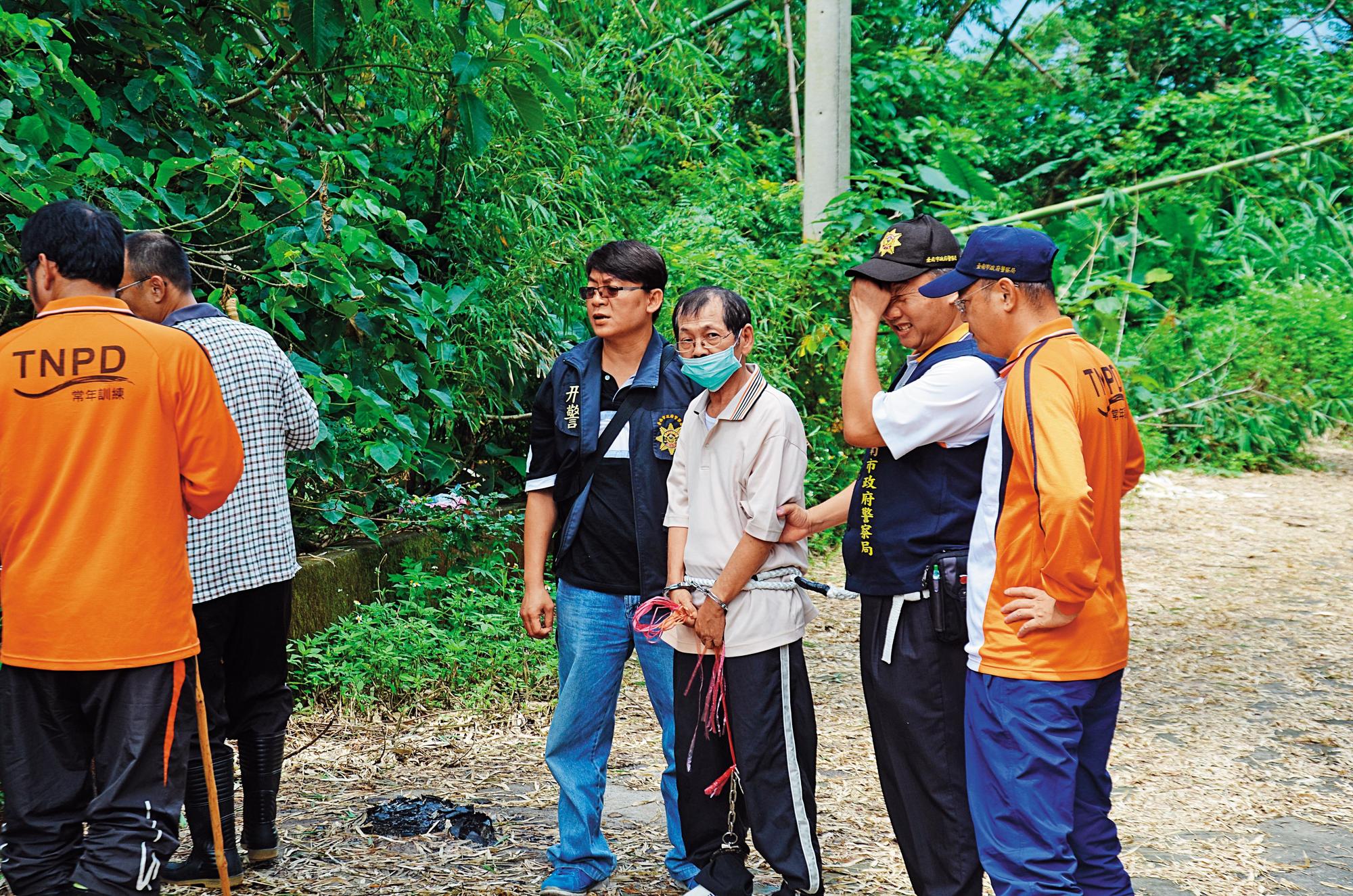 殺害同居人的凶手陳文釧,被警方帶回現場模擬。(翻攝畫面)