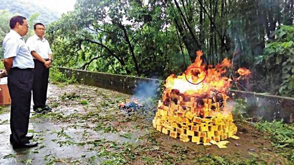 警方回現場祭拜亡靈,焚燒紙錢時,火焰中竟出現人臉(紅圈處)。(翻攝畫面)