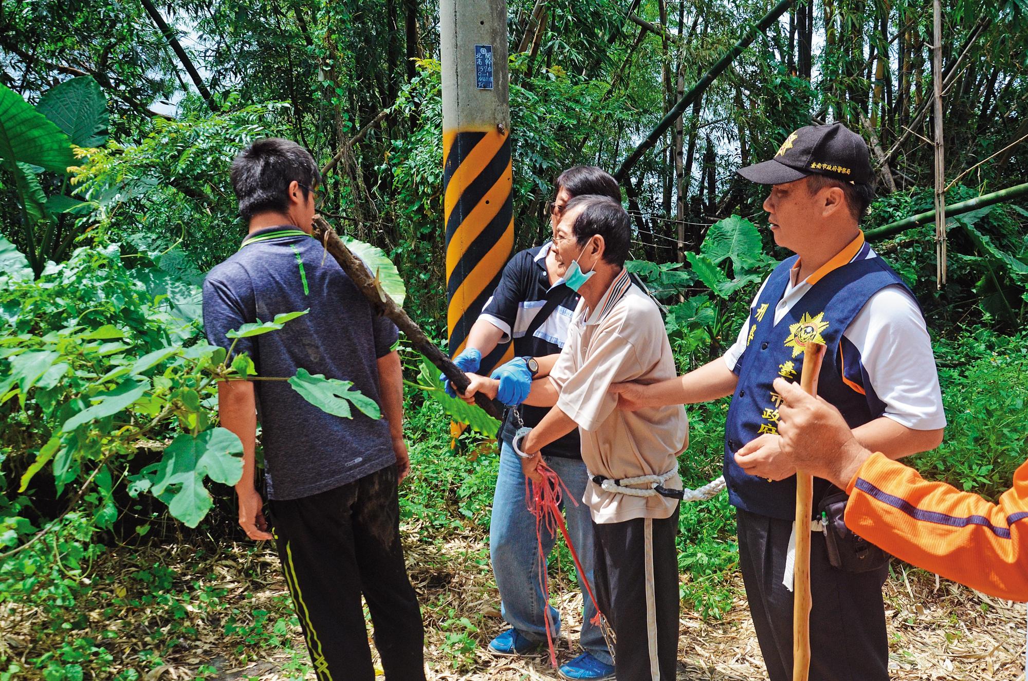 警方帶凶手陳文釧重回現場,模擬用木棍打死同居人的經過。(翻攝畫面)