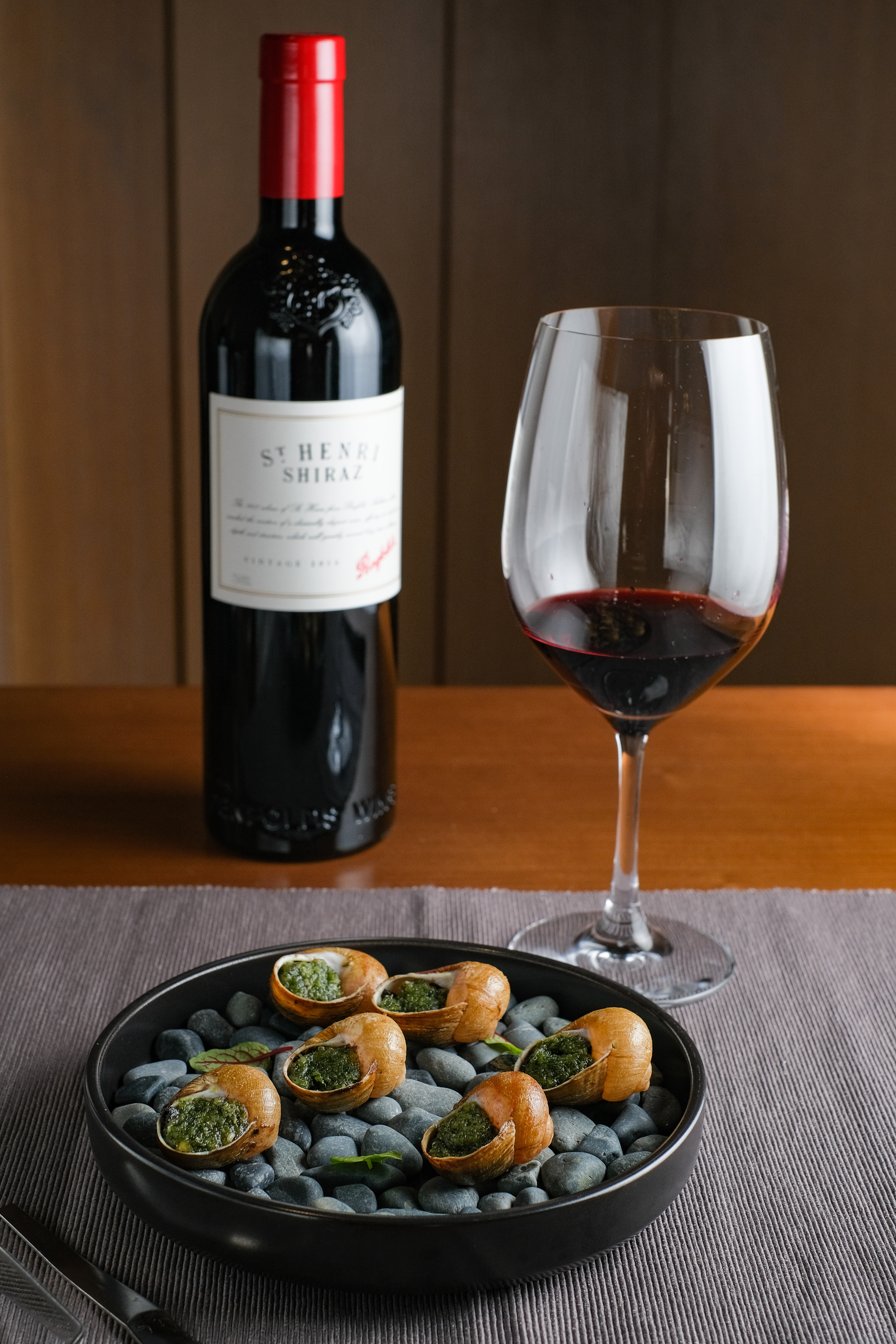 「ST. Henri Shiraz 2016聖亨利 希哈紅葡萄酒」的酸度，可平衡香料奶油焗烤田螺的濃重。（台中限定酒單供應2014年份，980元／杯、4,900元／瓶）