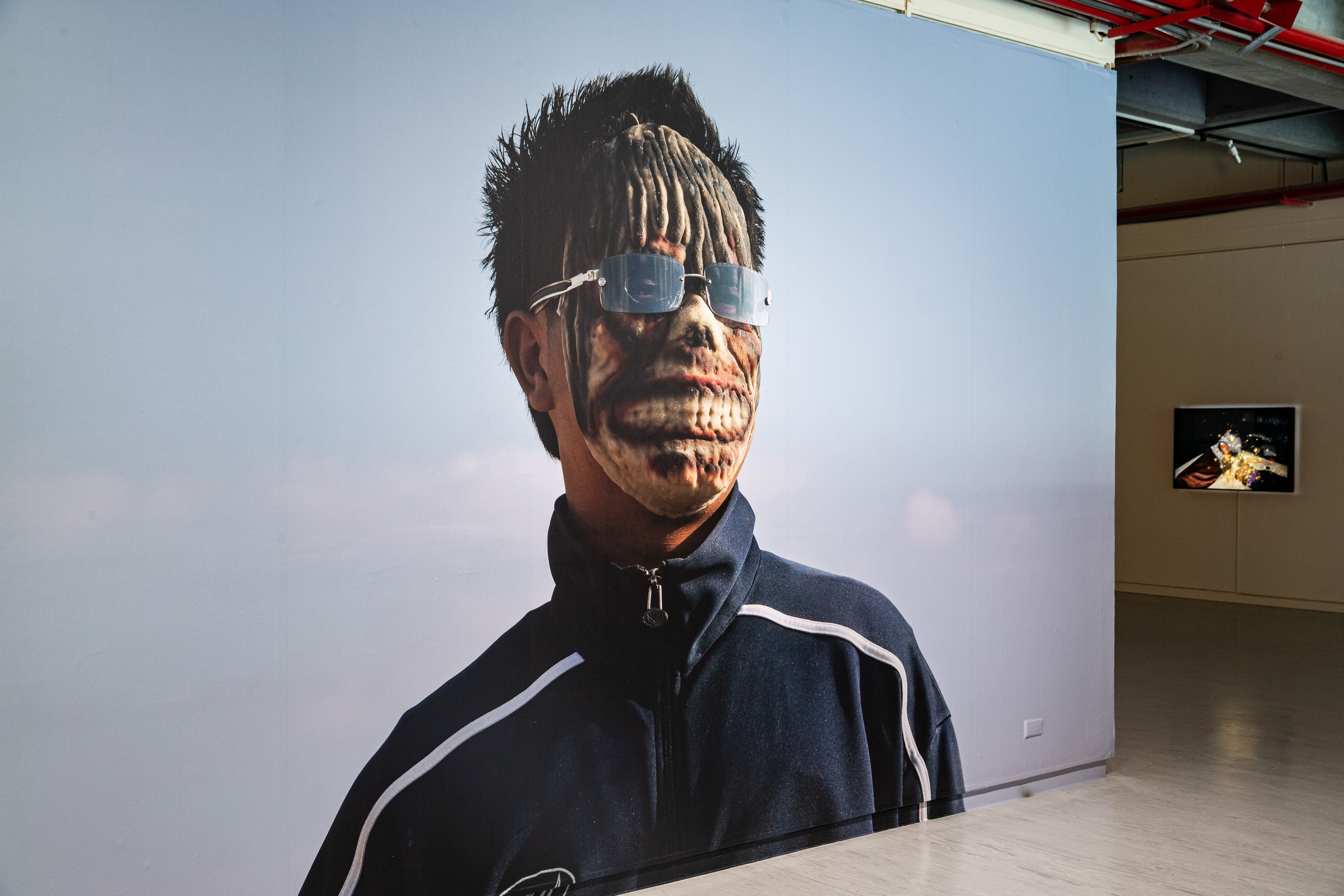 阿比查邦出身泰國東北孔敬市,作品關注鄉村歷史過往與青年的未來,展覽主視覺《鬼魂青年》是東北男孩戴著鬼魂面具、太陽眼鏡,象徵鬼魅對威權的拒斥。(北美館提供)