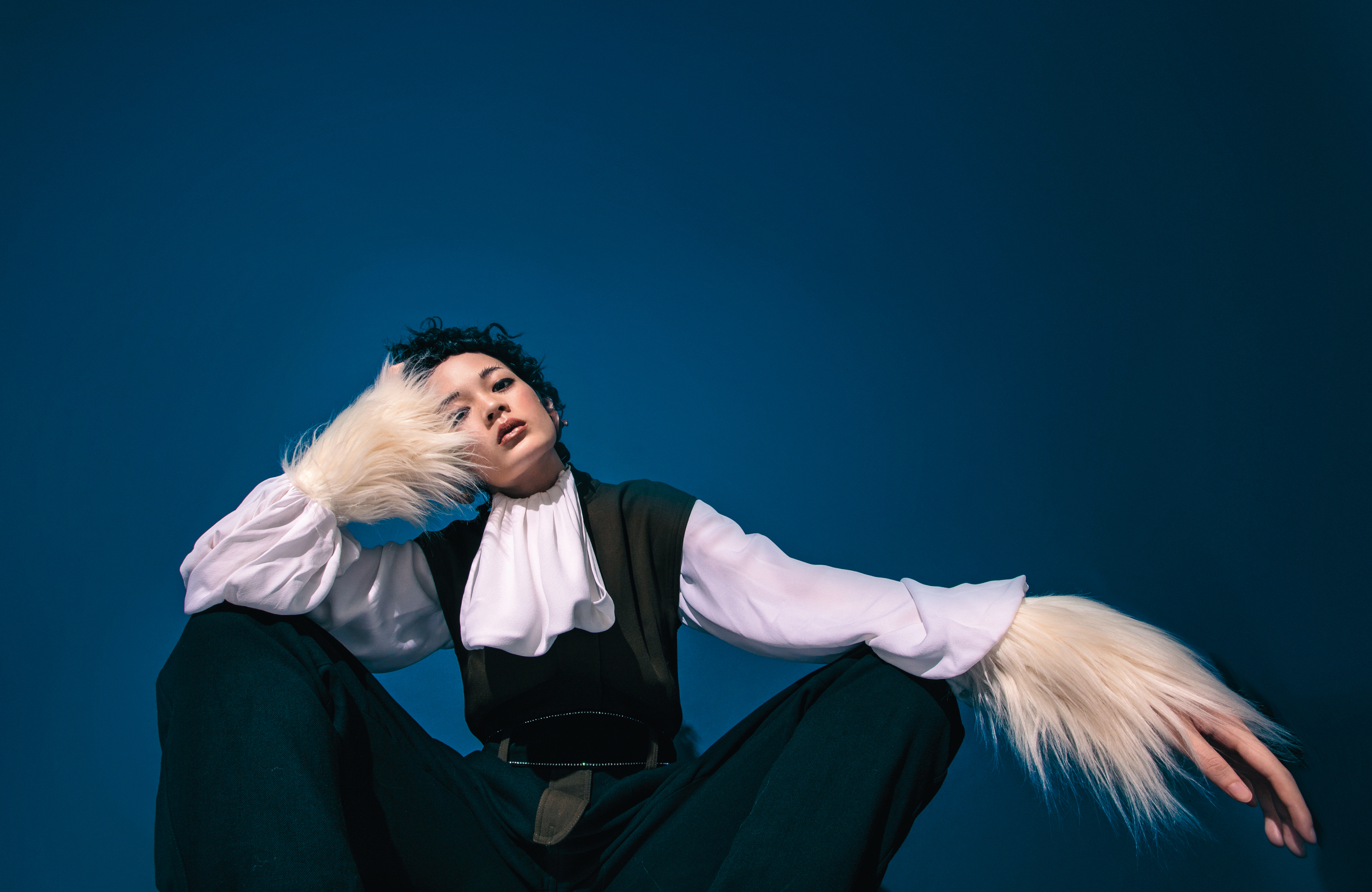 維多利亞風格白色襯衫 NT$46,000 by LOEWE／軍綠色拼接黑色連身褲 NT$69,000 by LOEWE／曲狀原木鍍金耳環 NT$40,400 by Bottega Veneta／純白人造皮草手套 NT$18,000 by GUCCI／ 沿邊鑲鑽腰綁帶 NT$6,030 by maje。