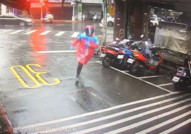 縱火的雨衣怪客向附近巷道內逃竄。（翻攝畫面）