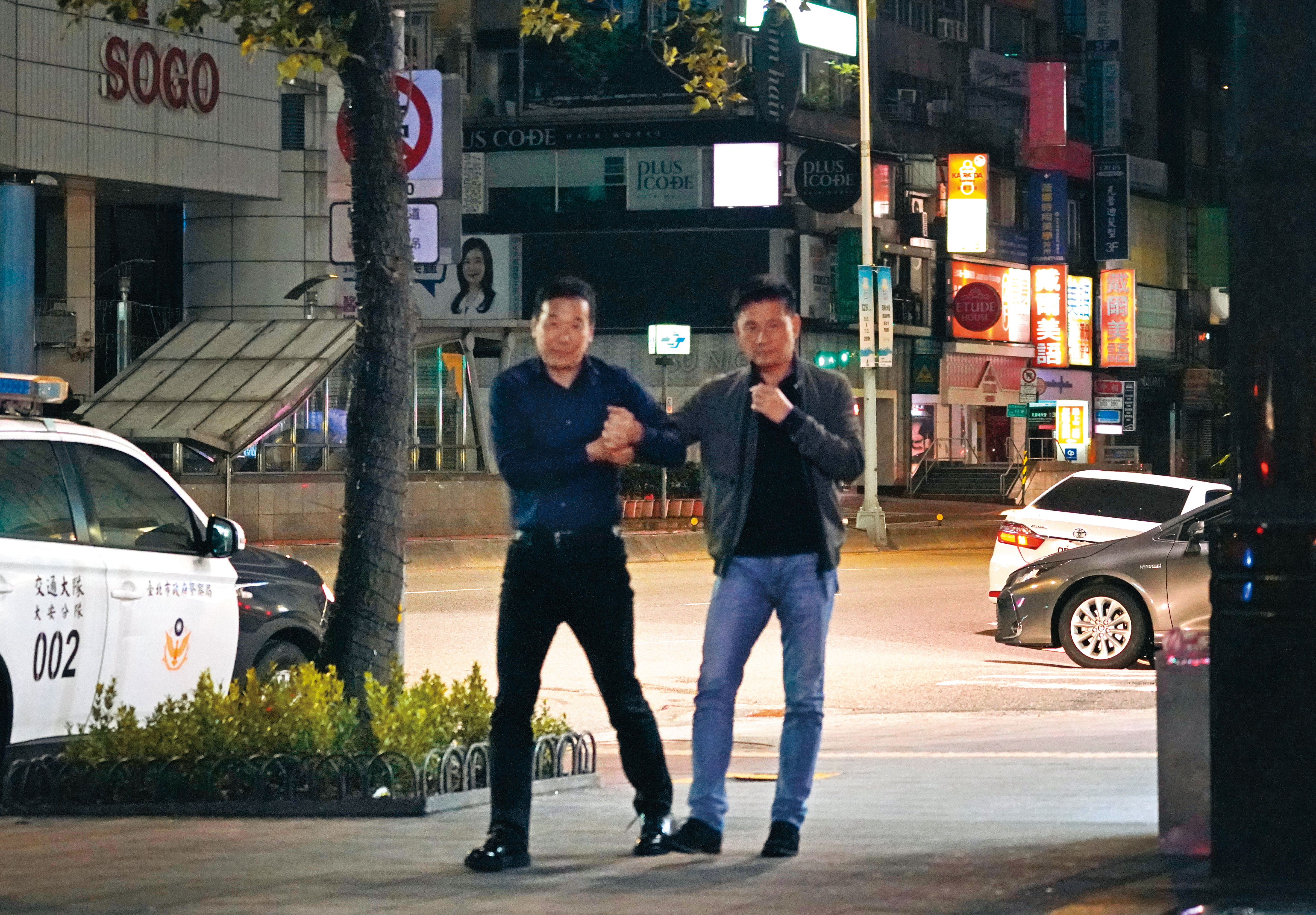11/28 03：03，鍾小平（左）扶著醉漢戴錫欽從錢櫃走出，並在路上招計程車。
