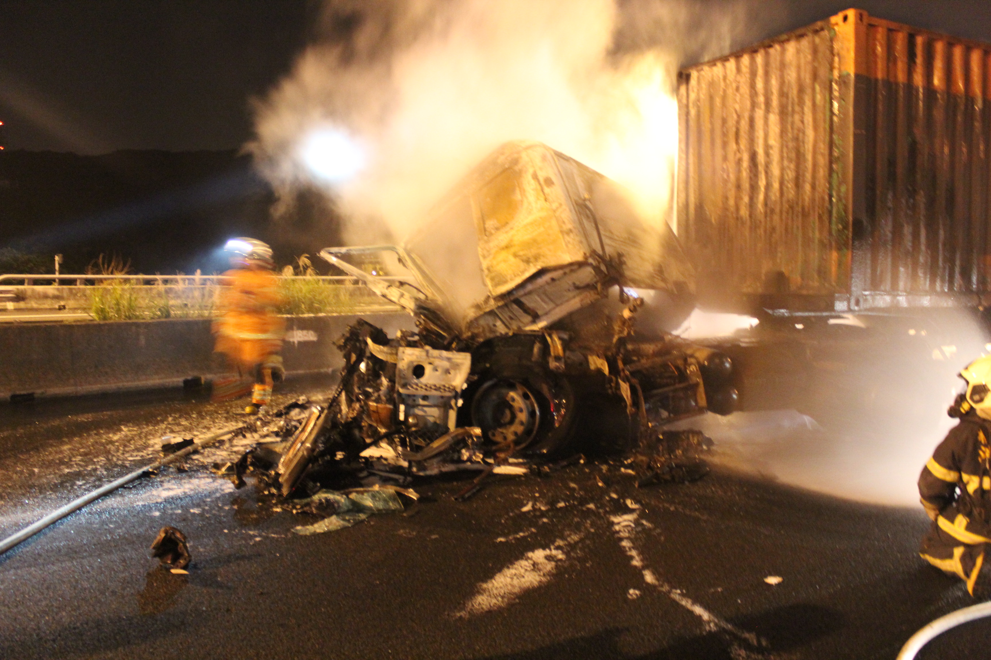 貨櫃車頭在追撞聯結車後，瞬間起火燃燒，警消趕到立即布水線灌救。（翻攝畫面）