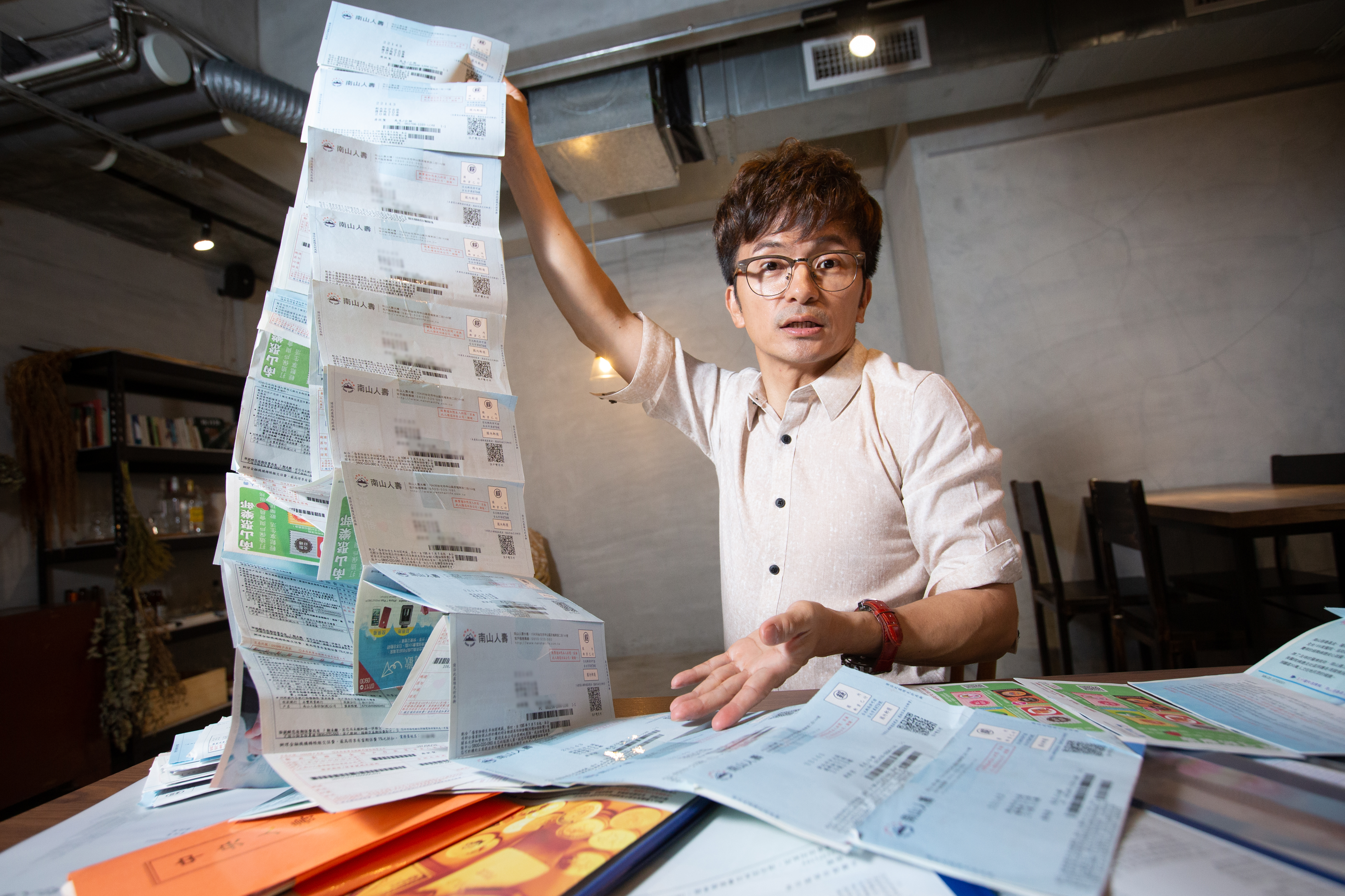 唐從聖把保單繳費通知單黏貼成串，綿延好幾公尺長，堪稱演藝圈保險大戶。