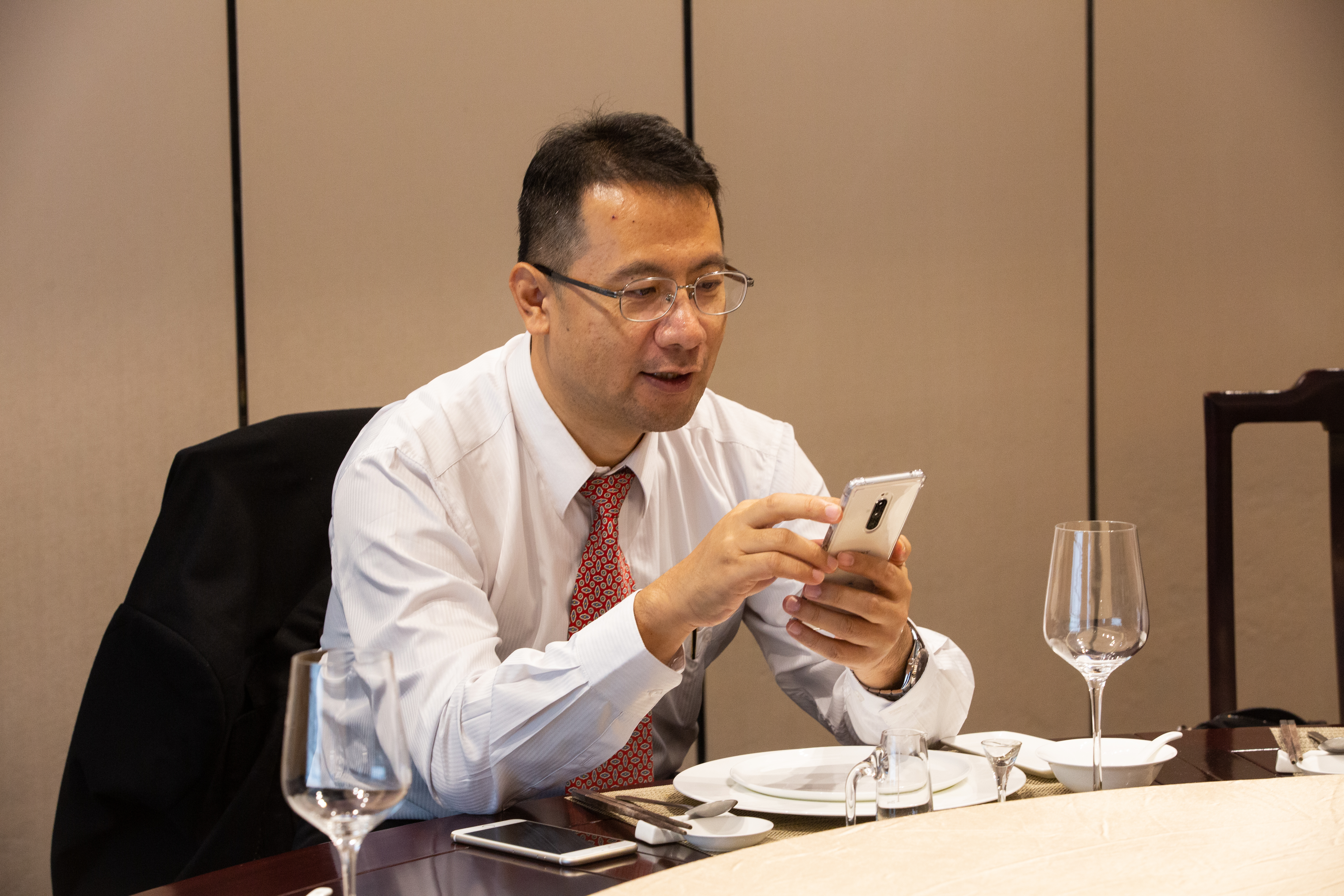 曾山一堅持不用祕書，出差時帶2支手機，飯局空檔忙著回覆訊息，1分鐘都不浪費。