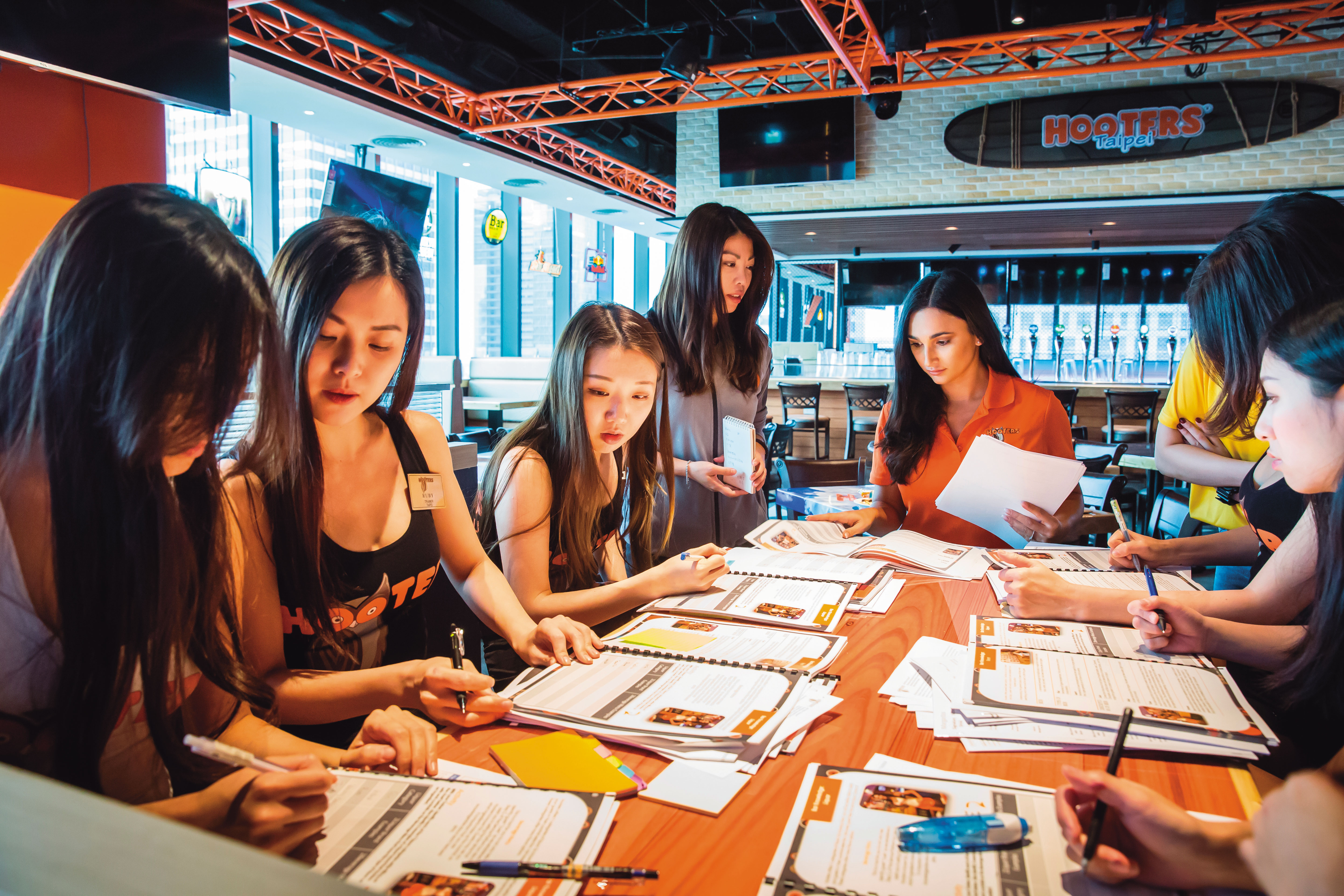 只要有展店，美國總部就會派人來加強上課。圖為Hooters girl們正在為即將開幕的信義店做筆記。