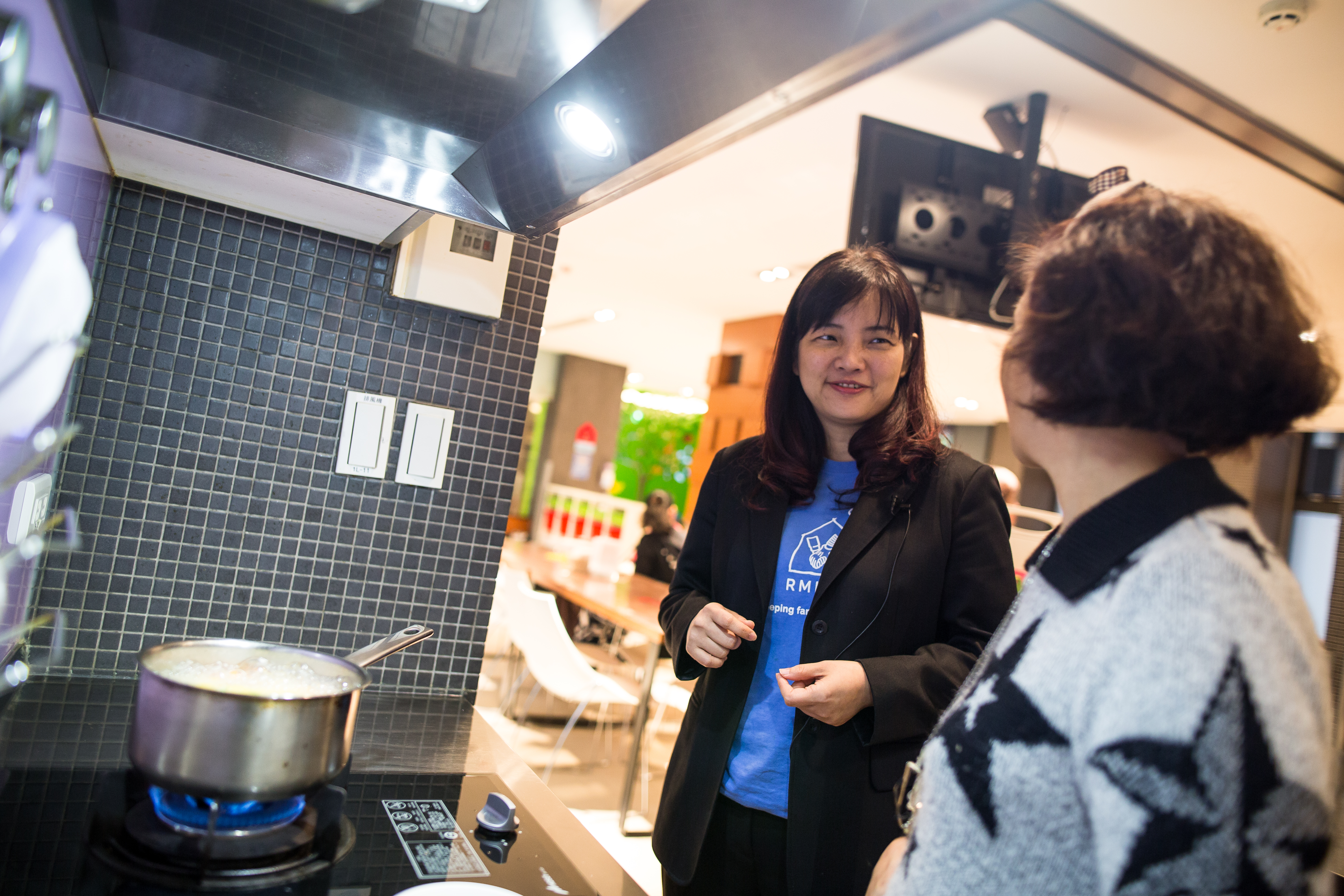 麥當勞叔叔之家慈善基金會執行長陶華君(左)和當天正在為孩子料理專屬午餐的房客閒聊。