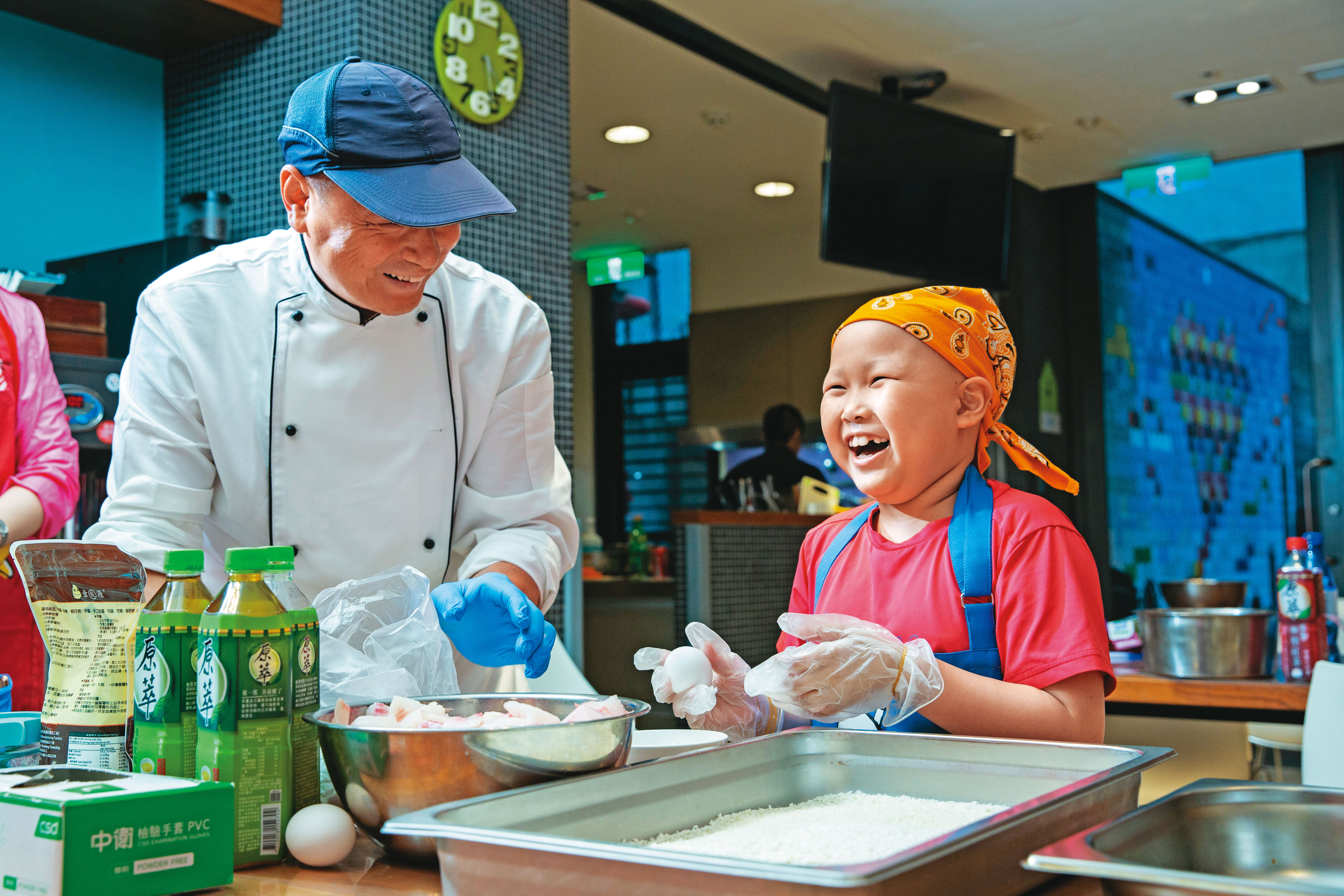 愛澄（右）活潑不怕生，遇到陌生人會主動自我介紹，也認真記著記者的名字。圖為她主動協助「主廚到我家」的大廚製作魚排。