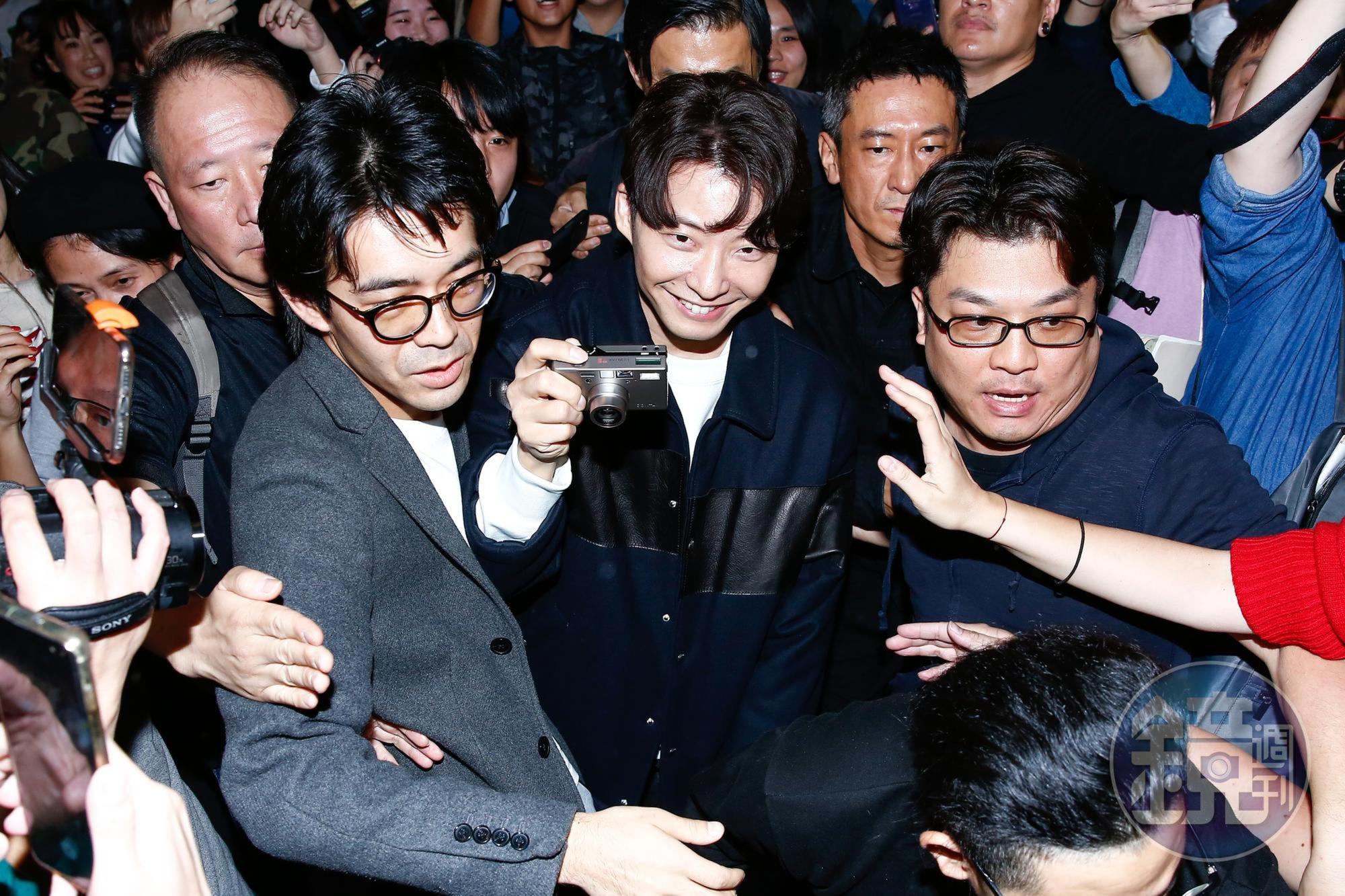 星野源開心拿著隨身相機拍照。