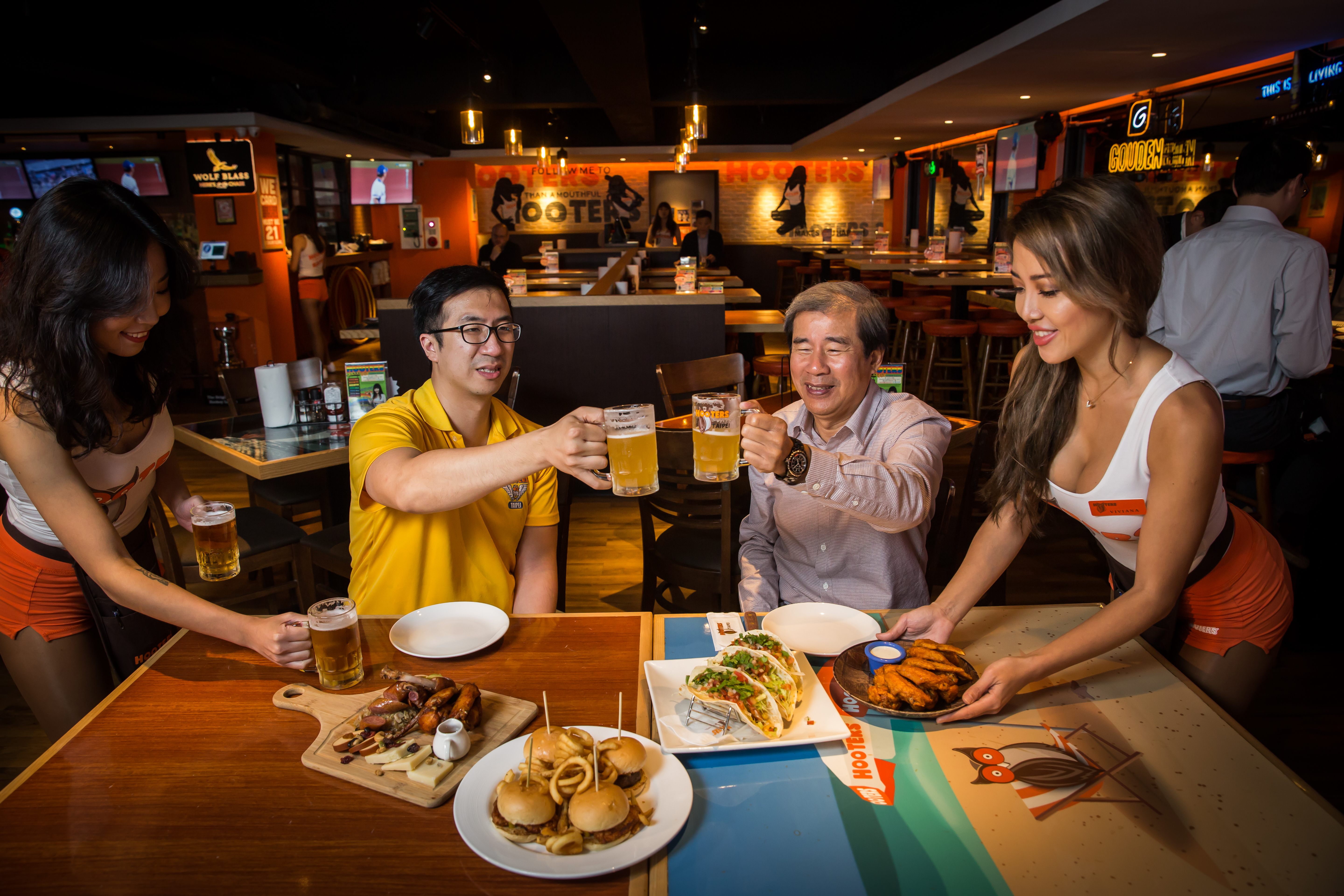 Hooters美式餐廳以熱情洋溢的辣妹服務生聞名，劉世章（右）22年前將其從美國引進，台北慶城店至今仍屹立不搖。兒子劉昶志現（左）也加入經營。