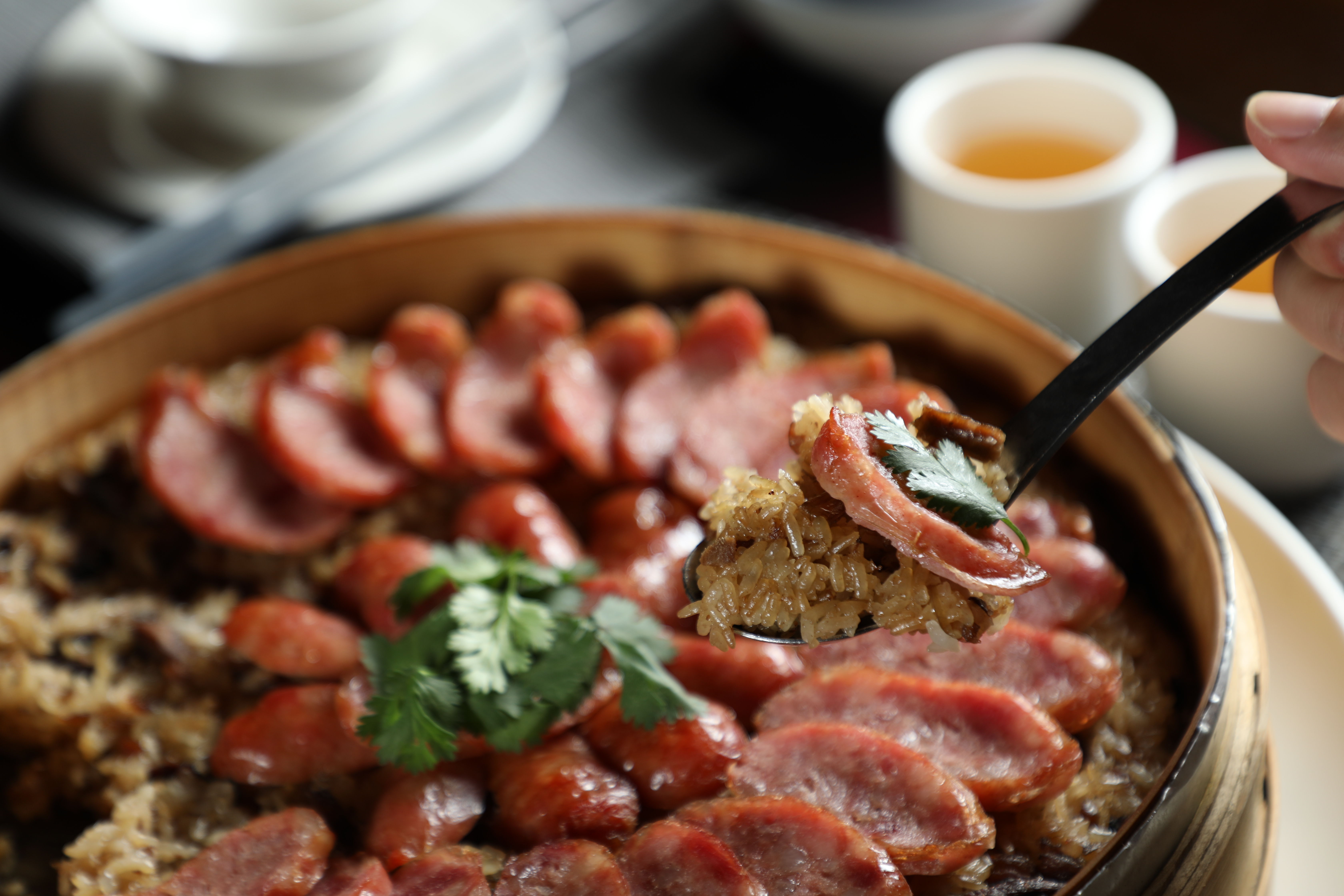 「荷葉香腸米糕」糯米飯吸滿蝦米、五花肉和紅蔥酥的香氣，香腸片甜香不油。（6,000元桌菜菜色）