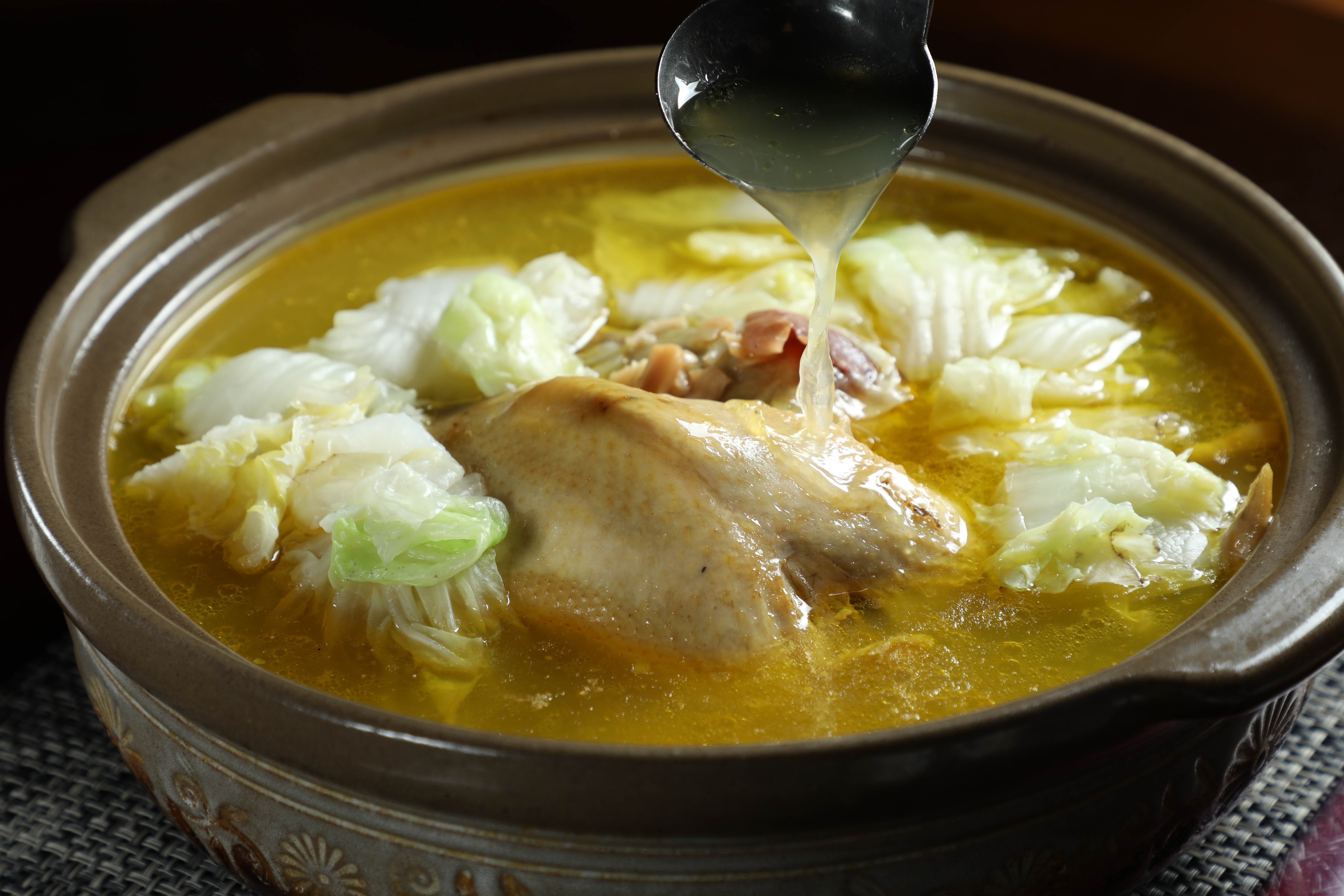 「富貴一品雞湯」呈現乳白色的湯頭，喝來清甜不油，還有土雞油脂的香氣，雞肉嫩而不柴。（10,000元桌菜菜色）