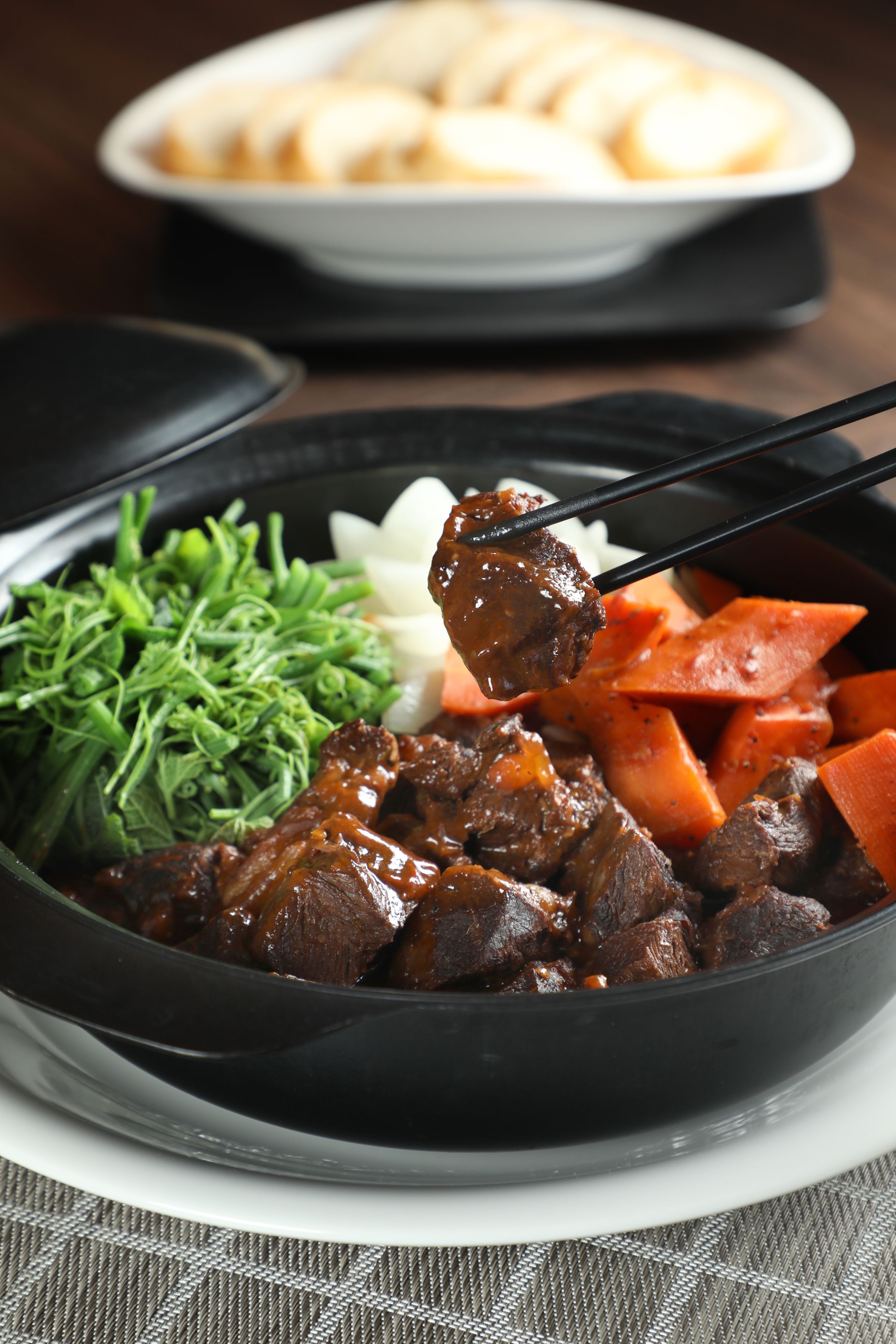 「冰酒慢燉牛臉頰」肉質一咬就散，能嗅到淡淡酒香，用迷迭香麵包蘸著醬汁吃，風味契合。（15,800元桌菜菜色）