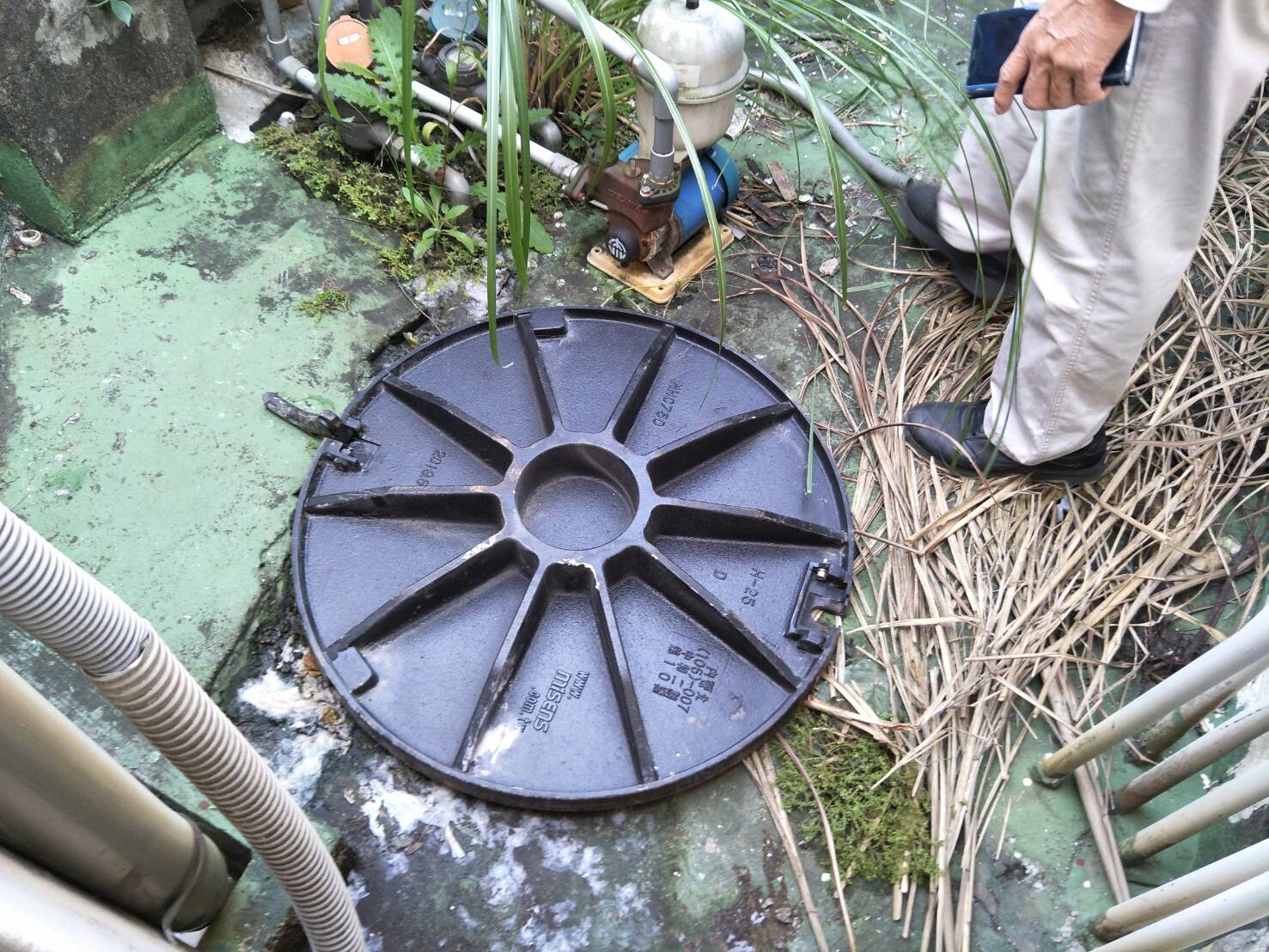 一塊重達100多公斤的人孔蓋，被爆炸威力彈飛砸傷2名工人。（翻攝畫面）