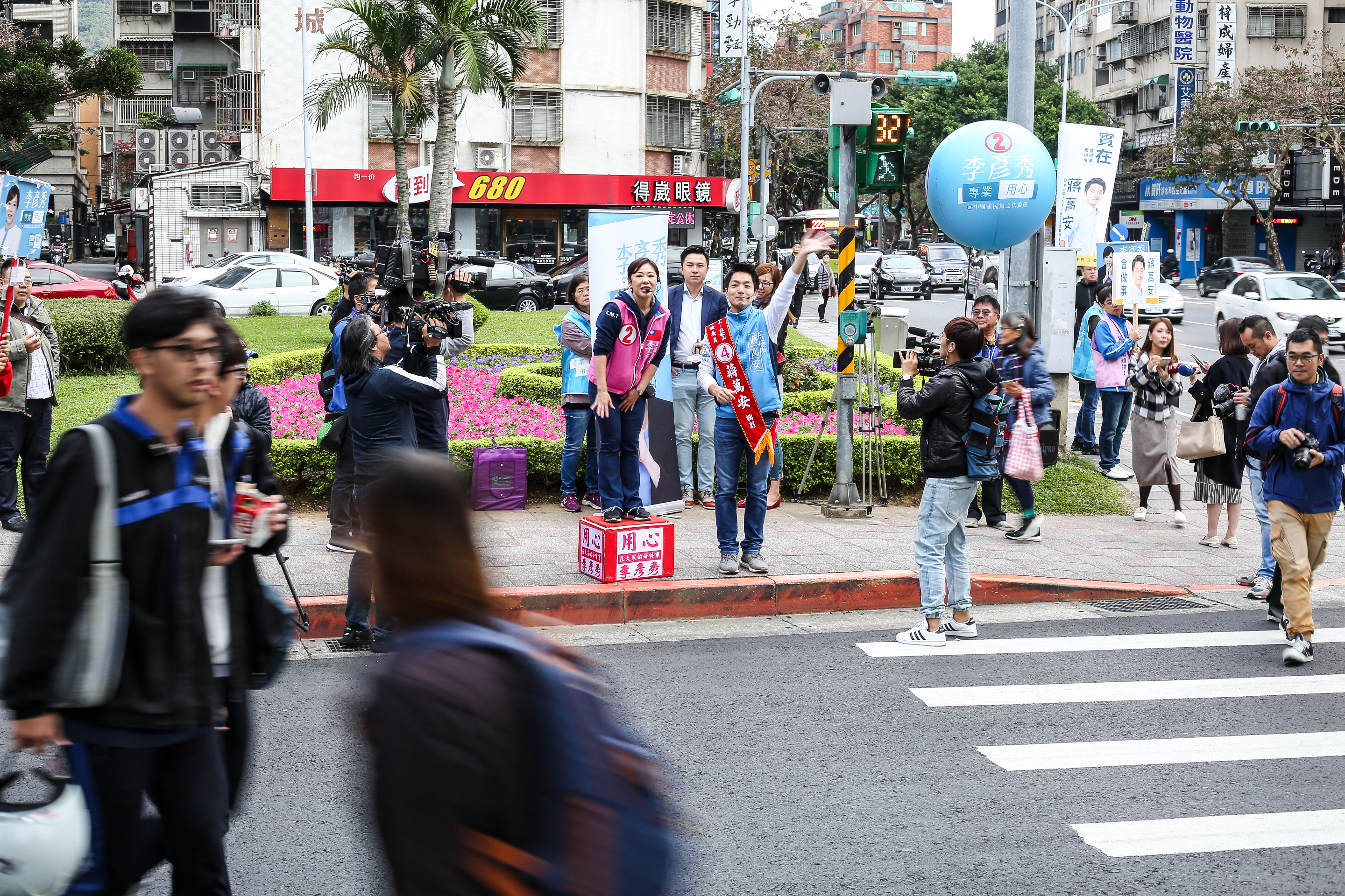 蔣萬安、李彥秀攜手站在內湖路港墘路口,與來往的民眾道早安。