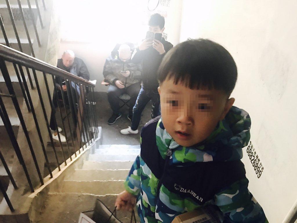 李文足住處樓梯間出現便衣人員阻止她外出,兒子也好奇這些人為何在家門外。(翻攝自李文足推特)