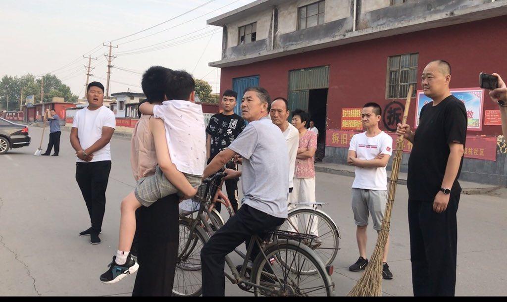 李文足（前左，抱孩子者）與當局動員前來騷擾的民眾理論。（翻攝自李文足推特）