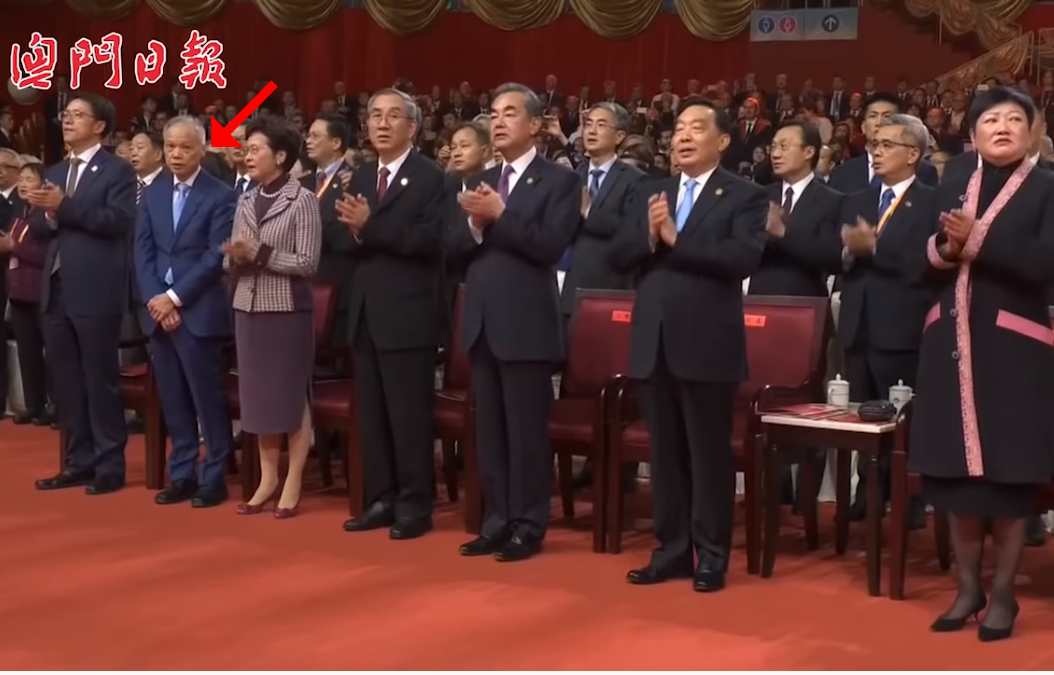 對比全場熱烈拍掌打拍子,林鄭月娥丈夫林兆波(紅箭頭處)不跟著唱《歌唱祖國》的身影,顯得相當突兀。(翻攝自澳門日報youtube影音)