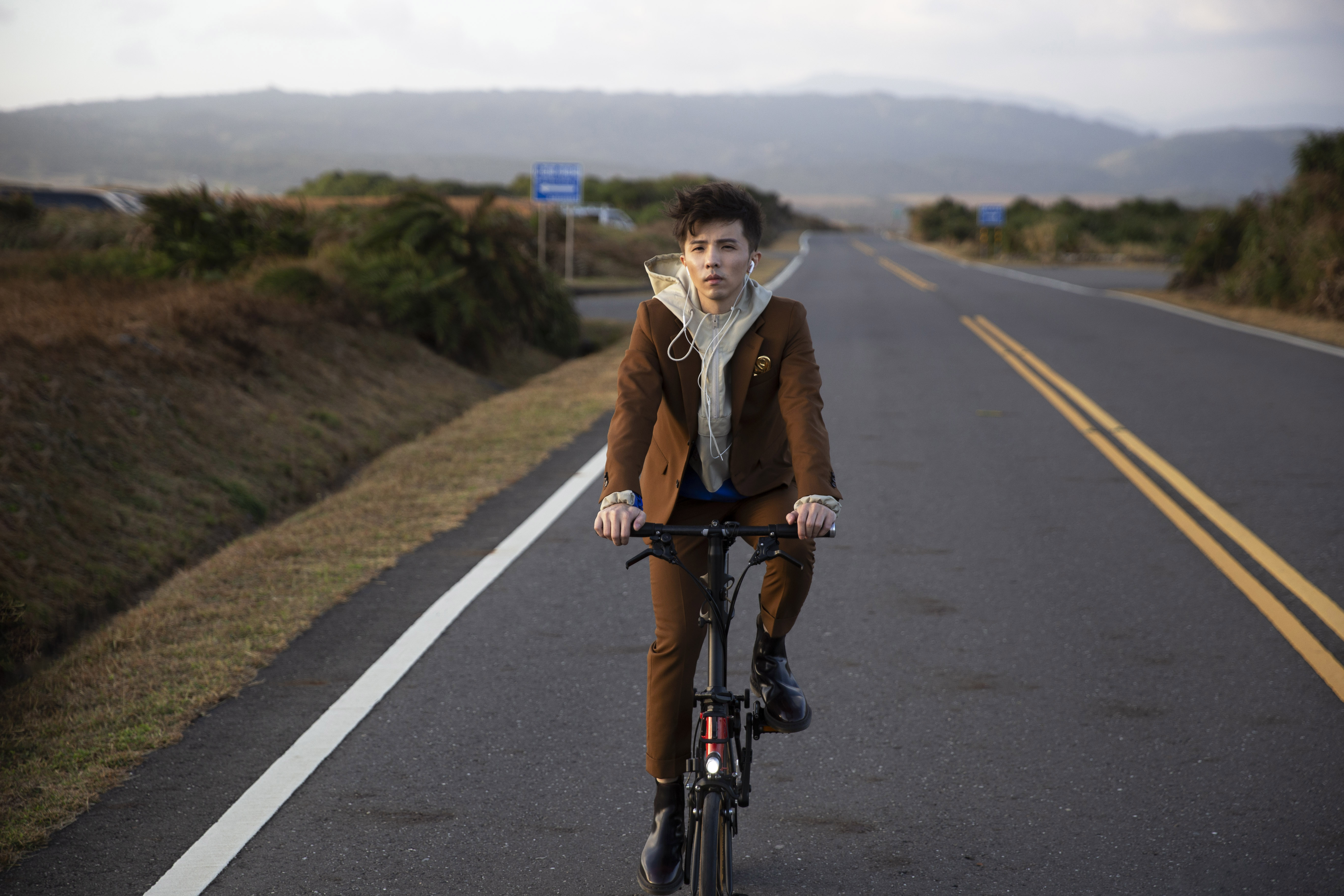 最近愛上小摺腳踏車的小宇，在公路拍攝時讓愛車亮相。（華納音樂提供）