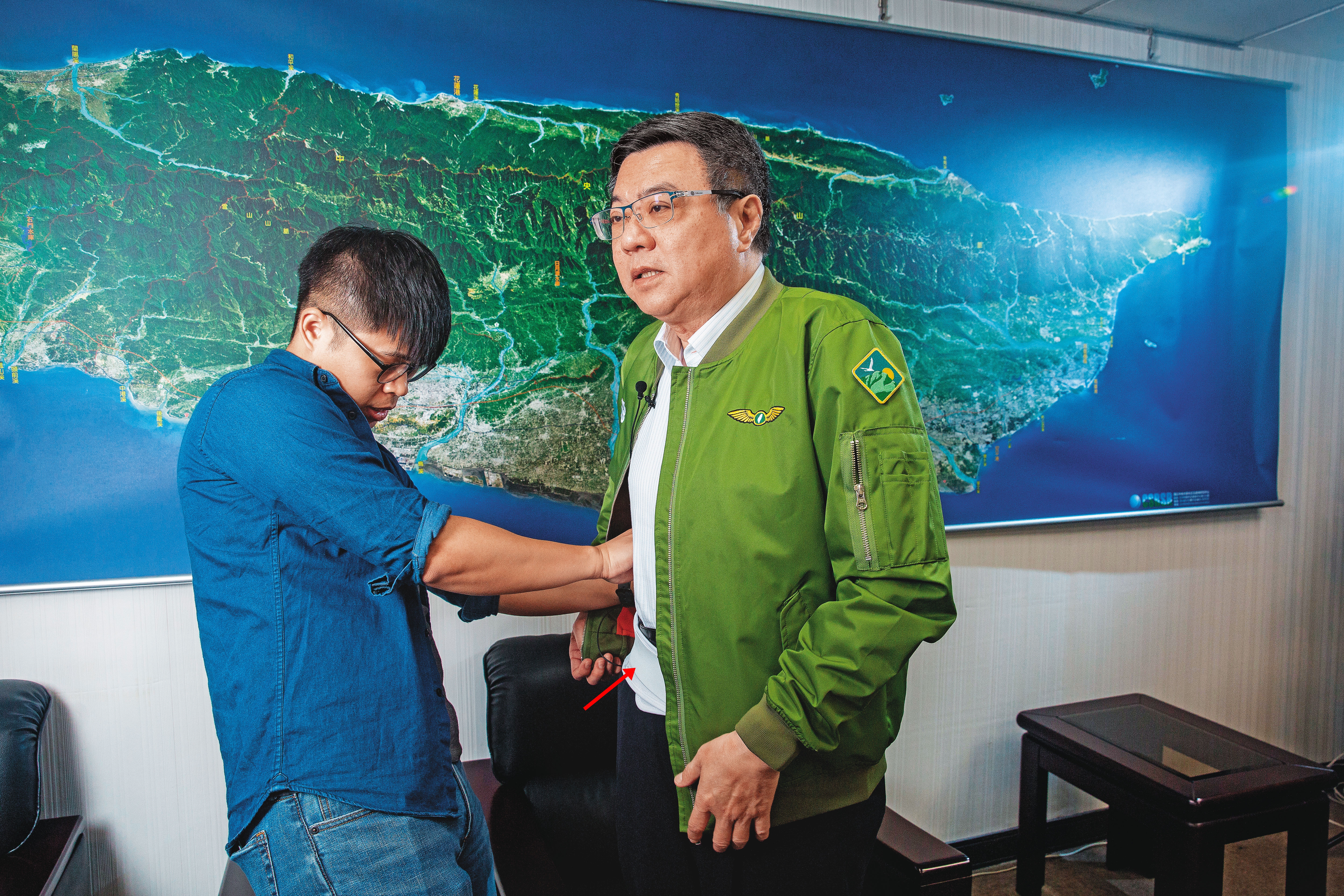 卓榮泰（右）跑遍全國各立委選區輔選，得靠護腰（箭頭處）保護腰部。