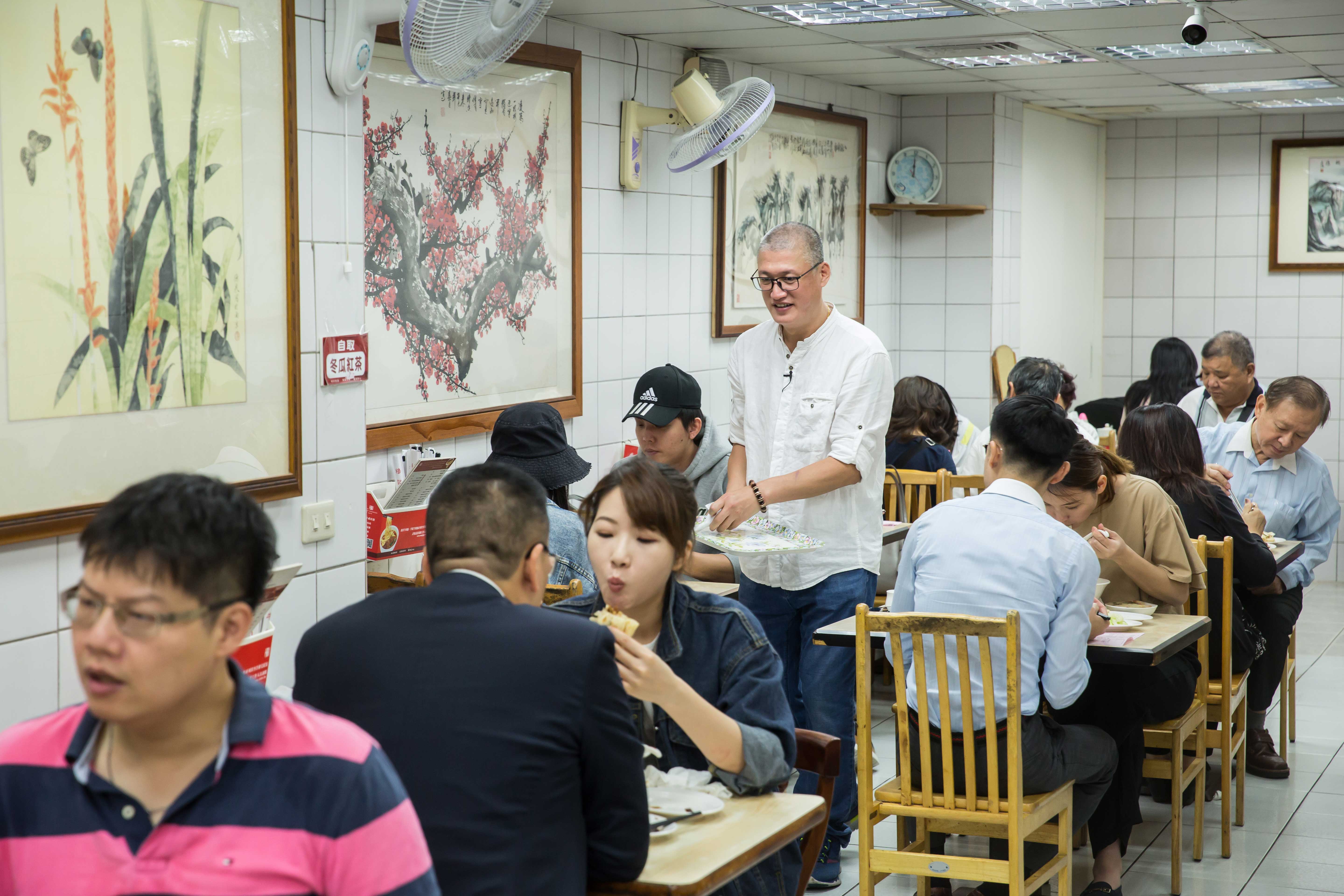 每逢用餐時間，穆記必定高朋滿座，周泰龍（站立者）已養成隨時觀察客人需求的眼力。