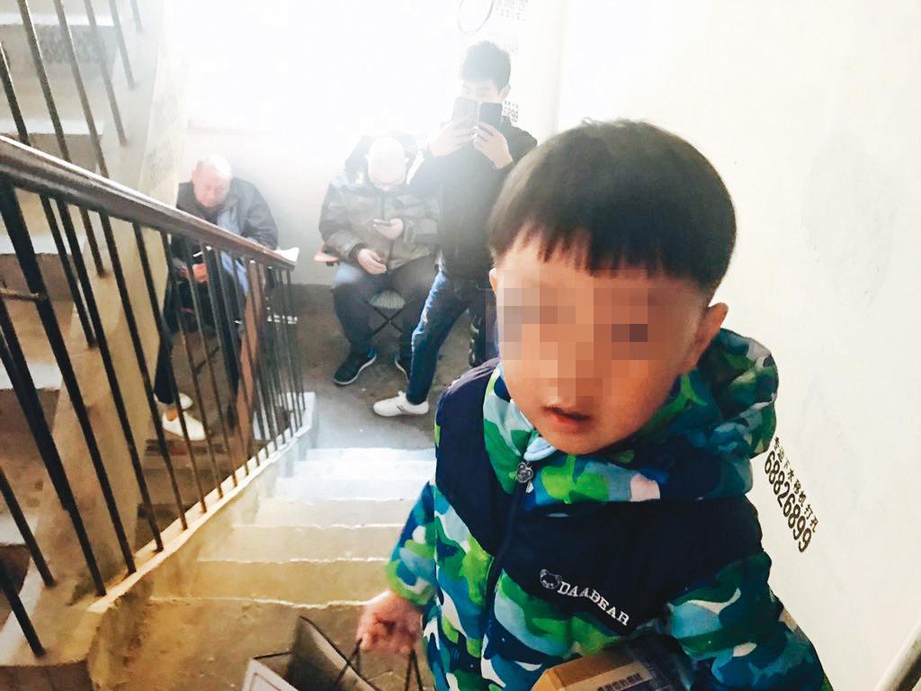 李文足住處樓梯間經常出現陌生黑衣人阻止她外出，甚至反拍她，幼兒無法理解為何這些人總在家門外。（翻攝自李文足twitter）