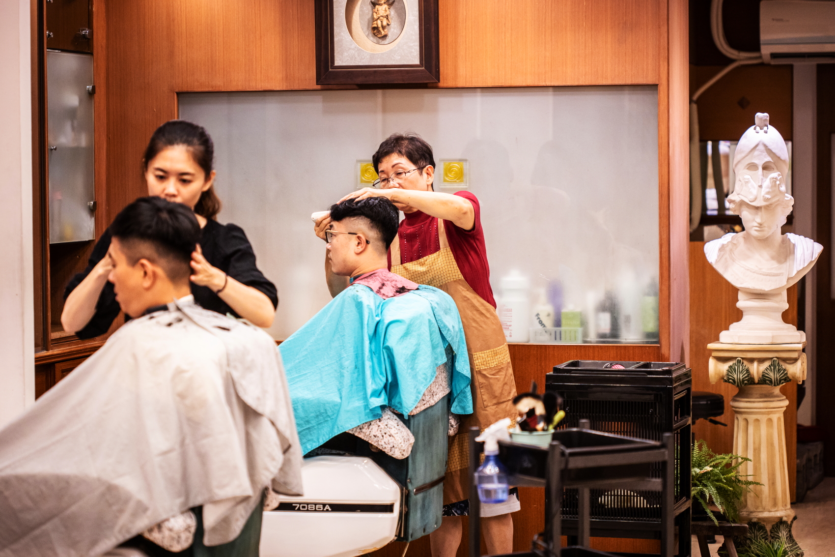 年輕人也喜歡上理容院剪髮和修容。（紳士修臉200元、紳士理髮500元起）