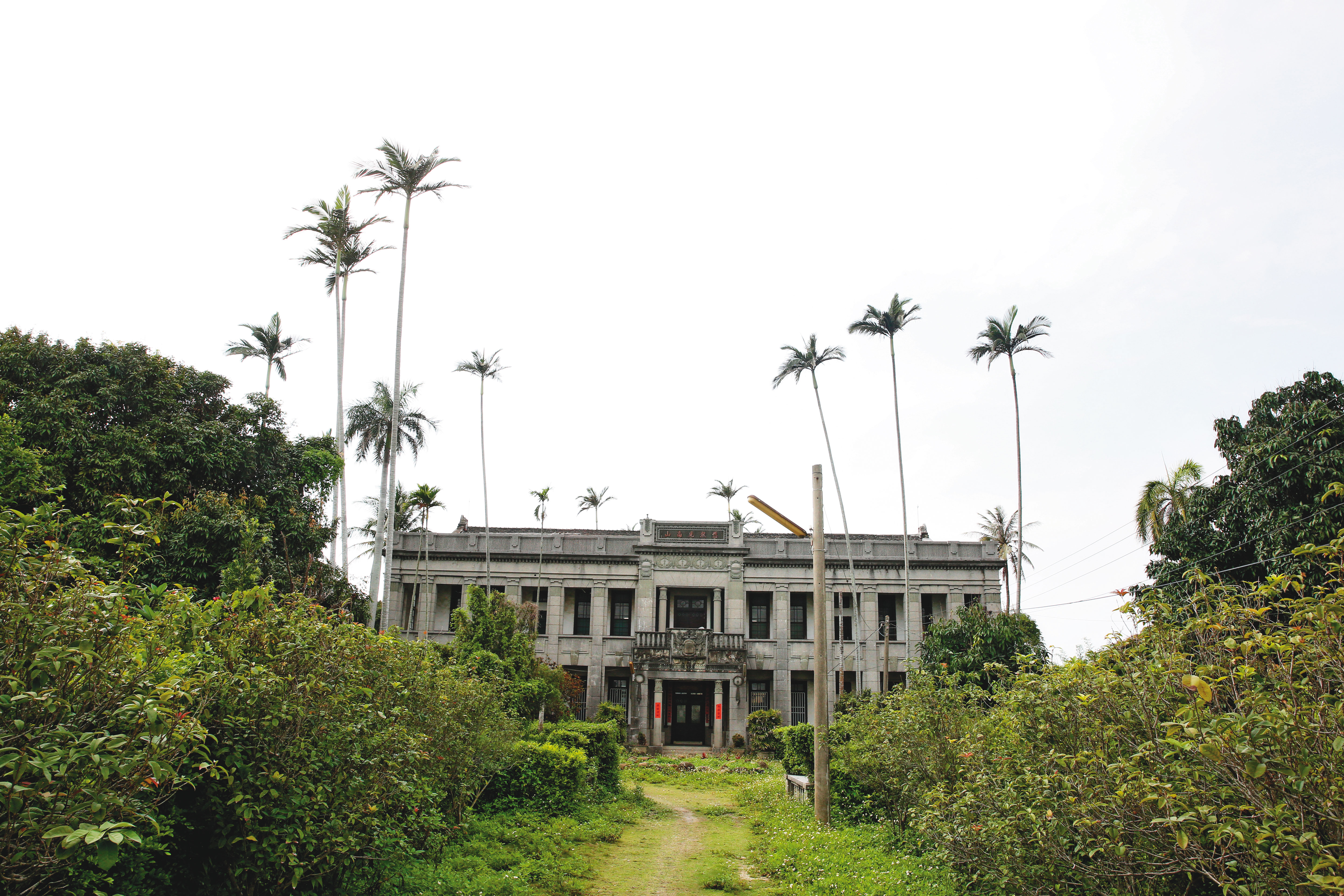 日月明功高中生虐死案發後， 囚禁少年詹淳寓的地點「默園」鐵門深鎖， 蔓草叢生。