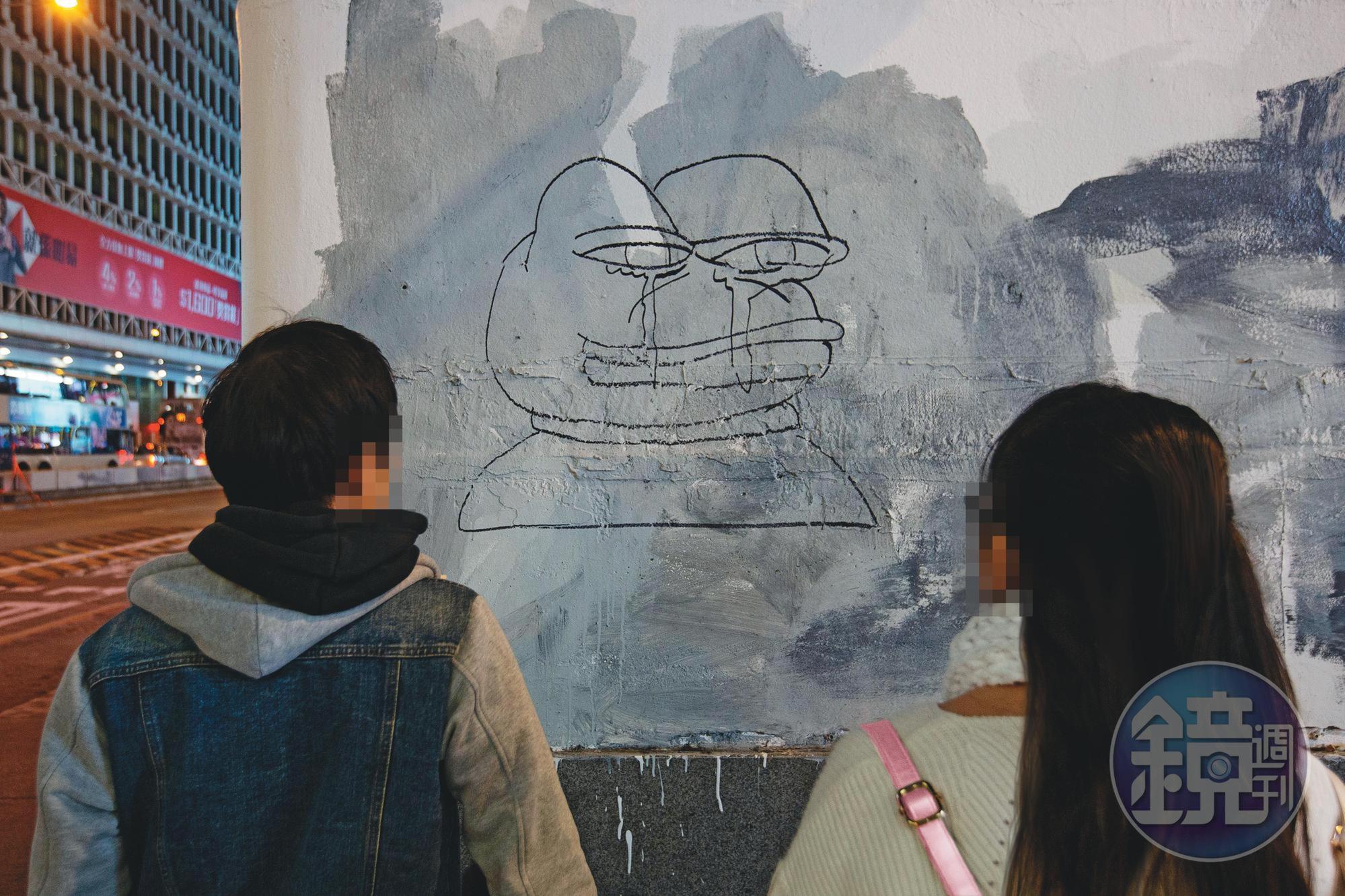 阿絲（右）和阿巴（左）駐足旺角街頭，停在反送中活動經常看到的「Pepe蛙」塗鴉前。
