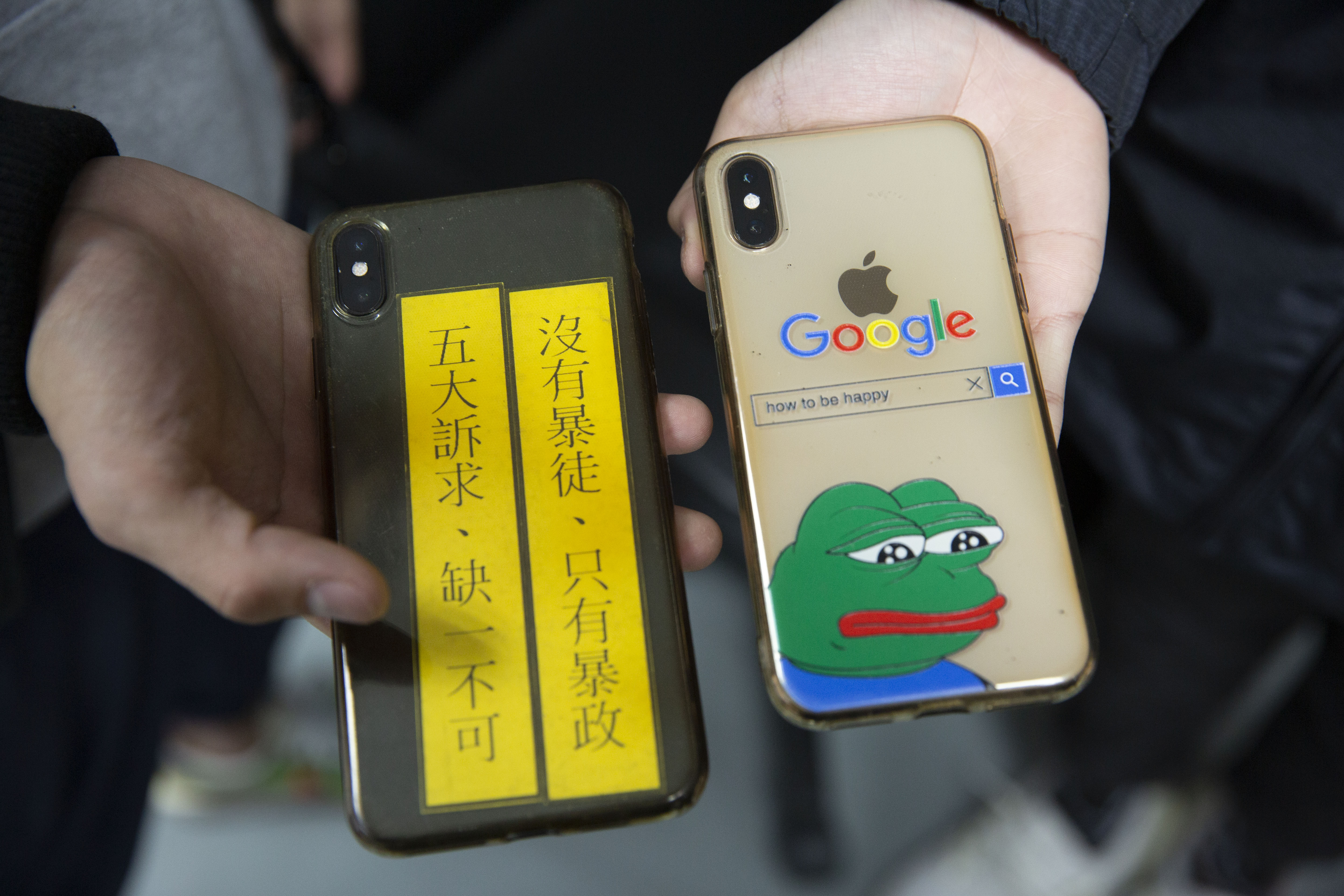 小雞和大寶拿出手機，兩人的手機殼不約而同穿上反送中主題的外衣。