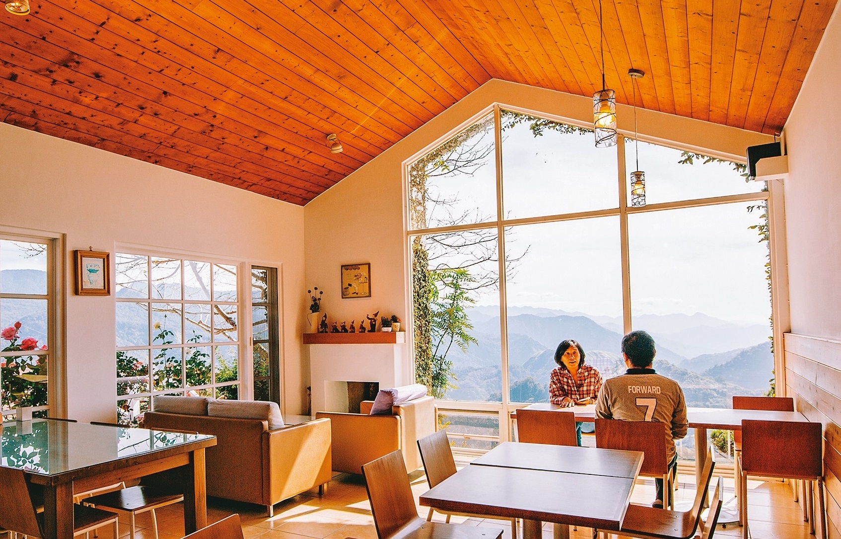 「茶香花園阿里山民宿」交誼廳內刻意保大面落地窗，將絕美山巒盡收眼底。