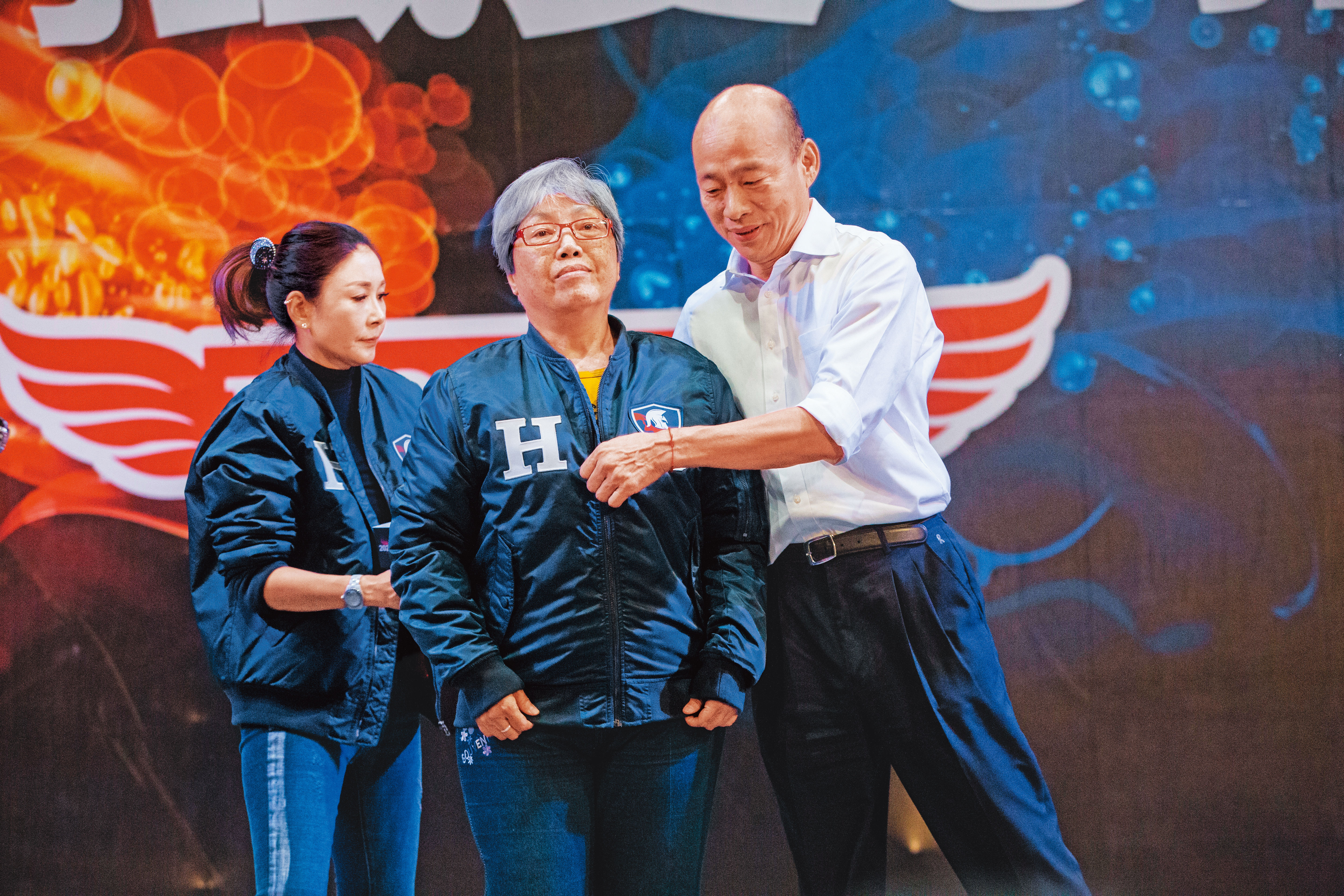 韓國瑜（右）日前賣出身上的「原味飛行夾克」，高雄謝女士（中）出價100萬元得標，她直呼：「好幸福。」