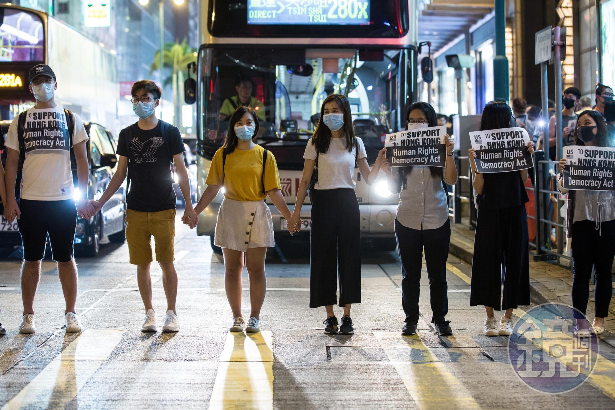 一名少女在人群中舉起「一疊白紙」抗議,遭香港警察以強光掃射臉部。(示意圖,非新聞當事人)