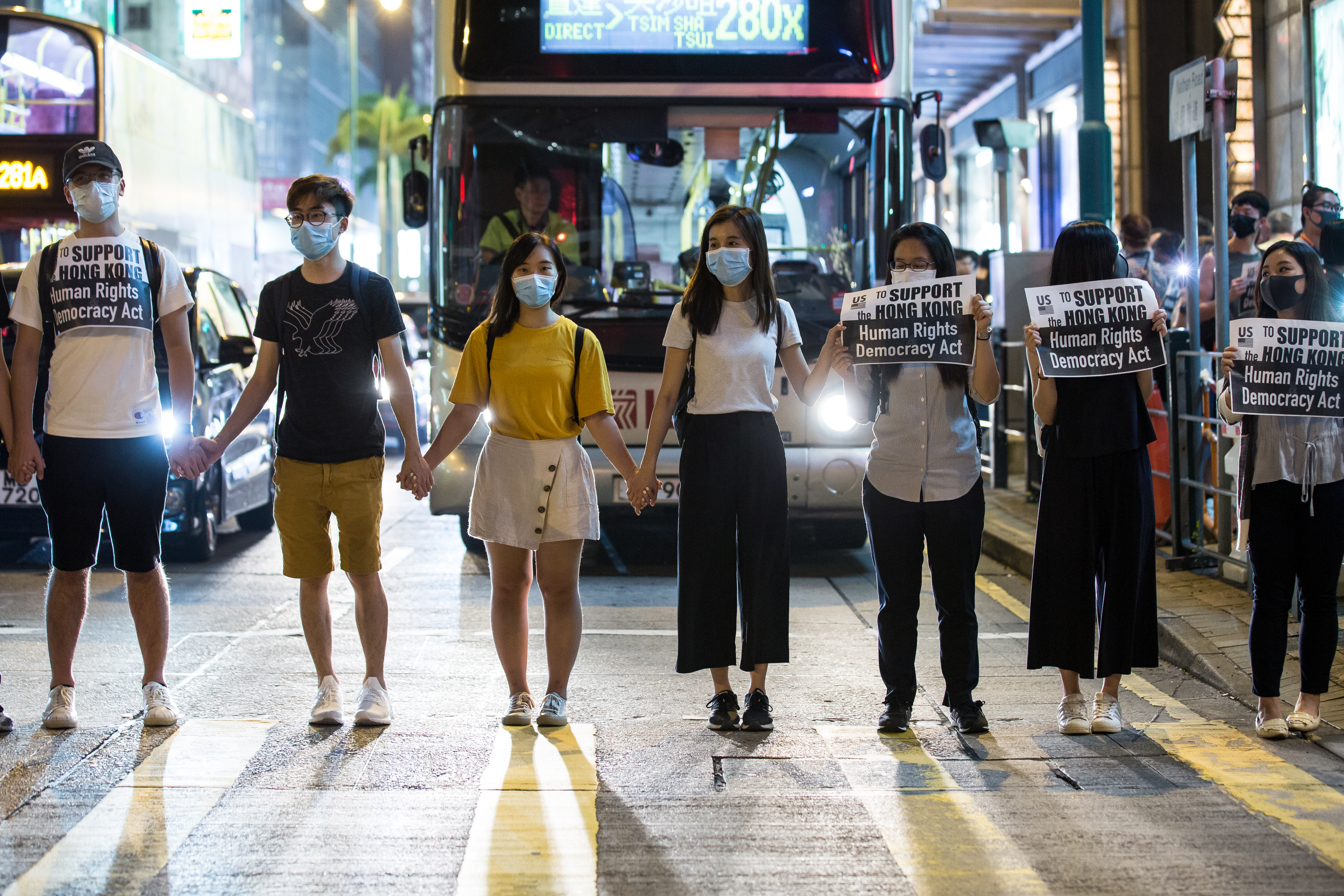 一名少女在人群中舉起「一疊白紙」抗議，遭香港警察以強光掃射臉部。（示意圖，非新聞當事人）
