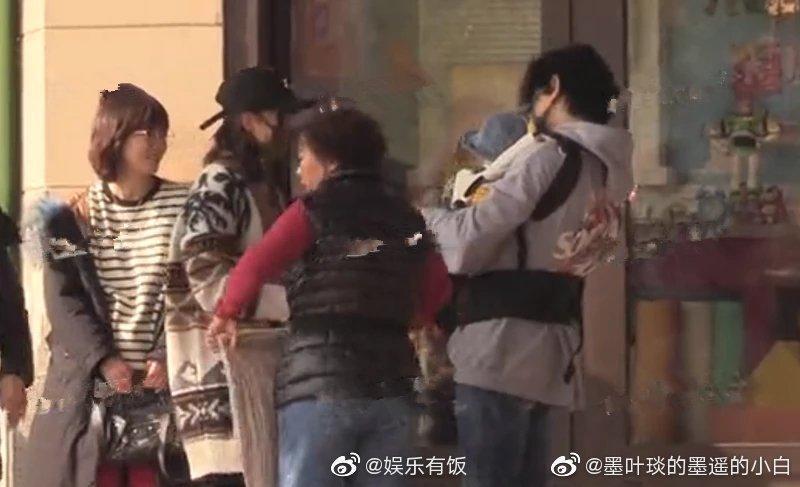 一路上幾乎都由保母或吳奇隆抱小孩,吳奇隆更套上嬰兒背帶,十足奶爸樣。(翻攝自微博)