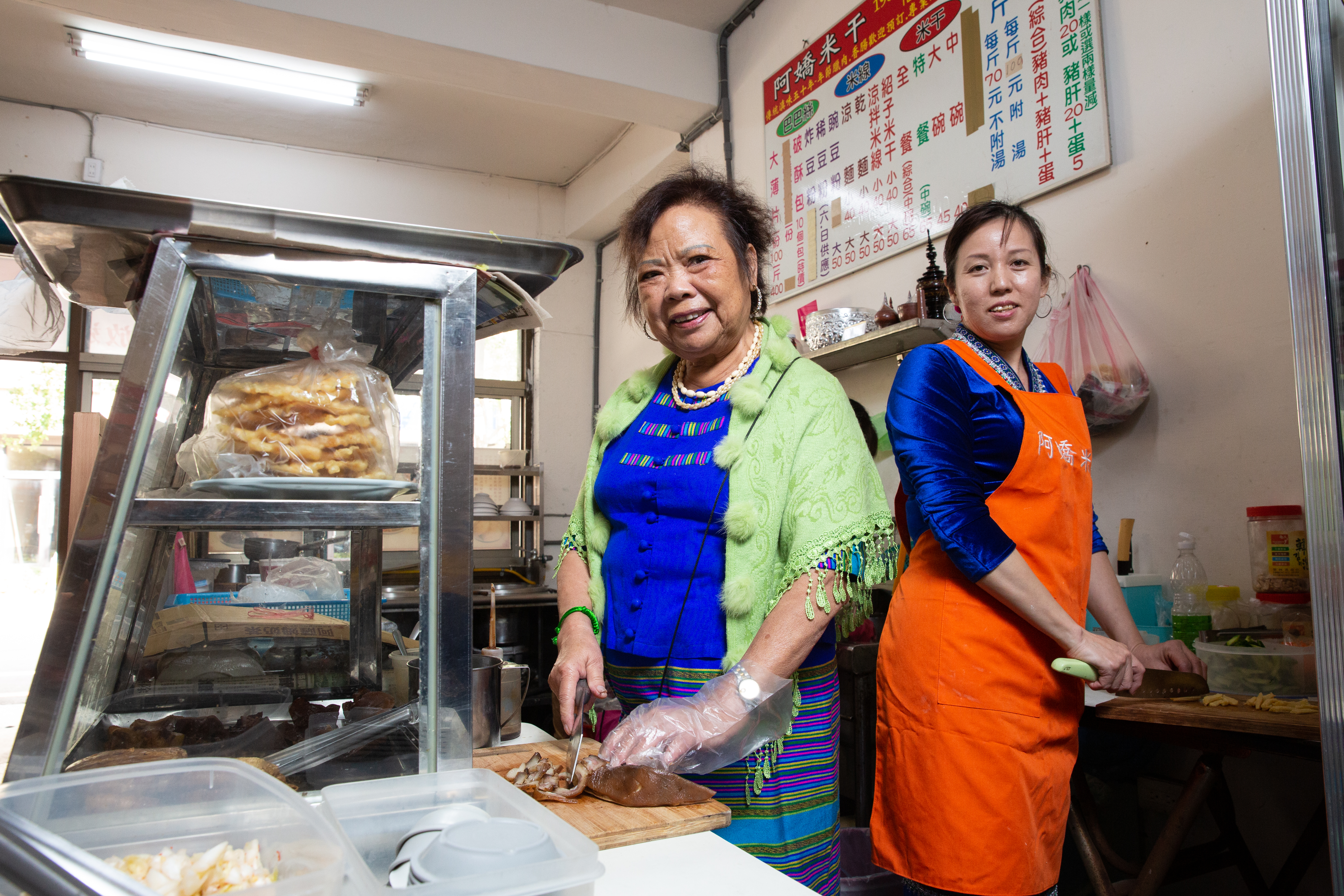 謝民嬌（右）與婆婆張玲慧情同母女，婆婆有空時會到店裡幫忙切米干、備料。