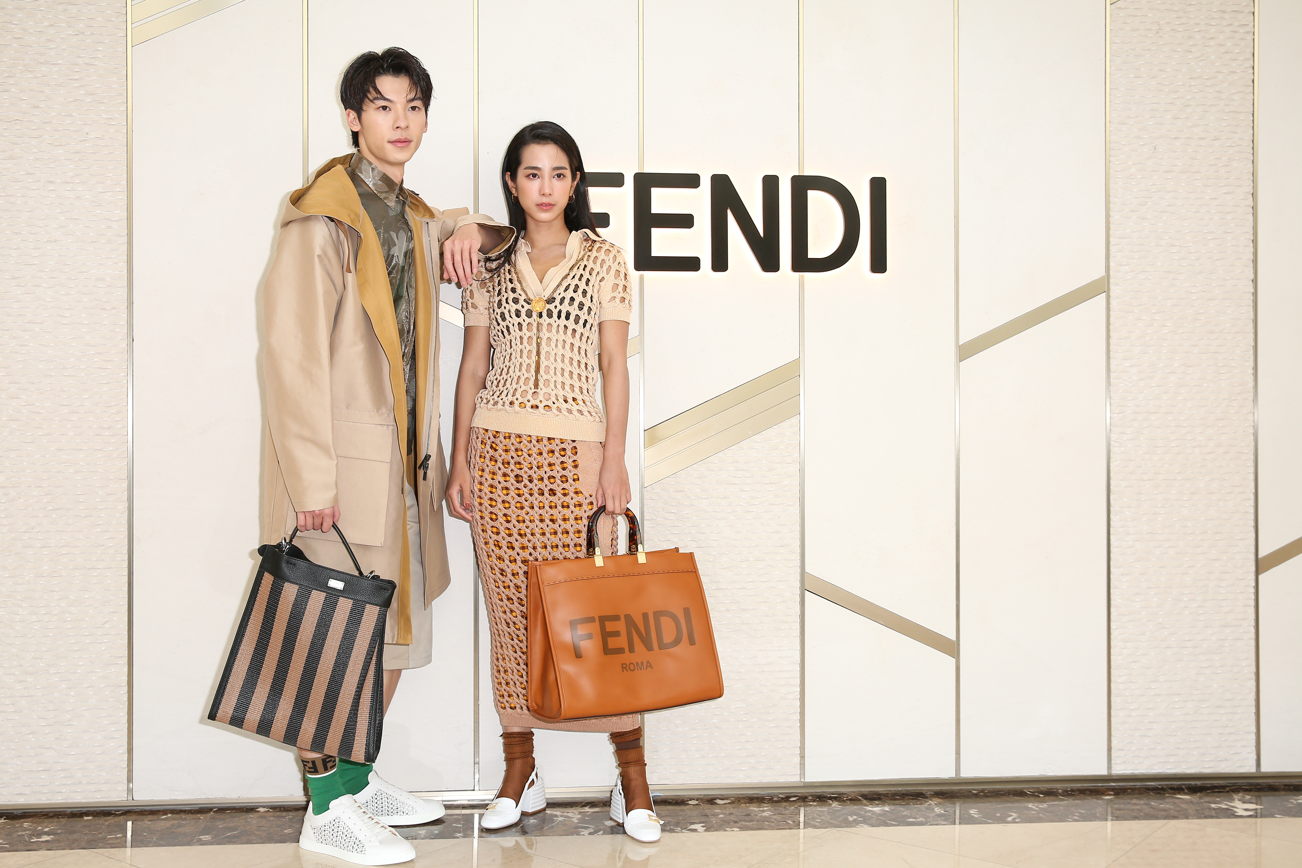 温貞菱穿著網狀設計上衣NT$63,900、網狀設計長裙NT$54,000；許光漢身著印花透視襯衫NT$26,000、男仕設計七分褲NT$30,500、男仕設計大衣NT$98,000、Peekaboo X-Lite Fit包款NT$132,000。