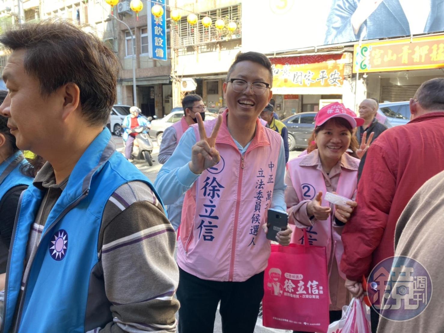 民眾黨的徐立信被藍營眾多的支持者卡在角落，只能無奈比出手勢苦笑。（讀者提供）